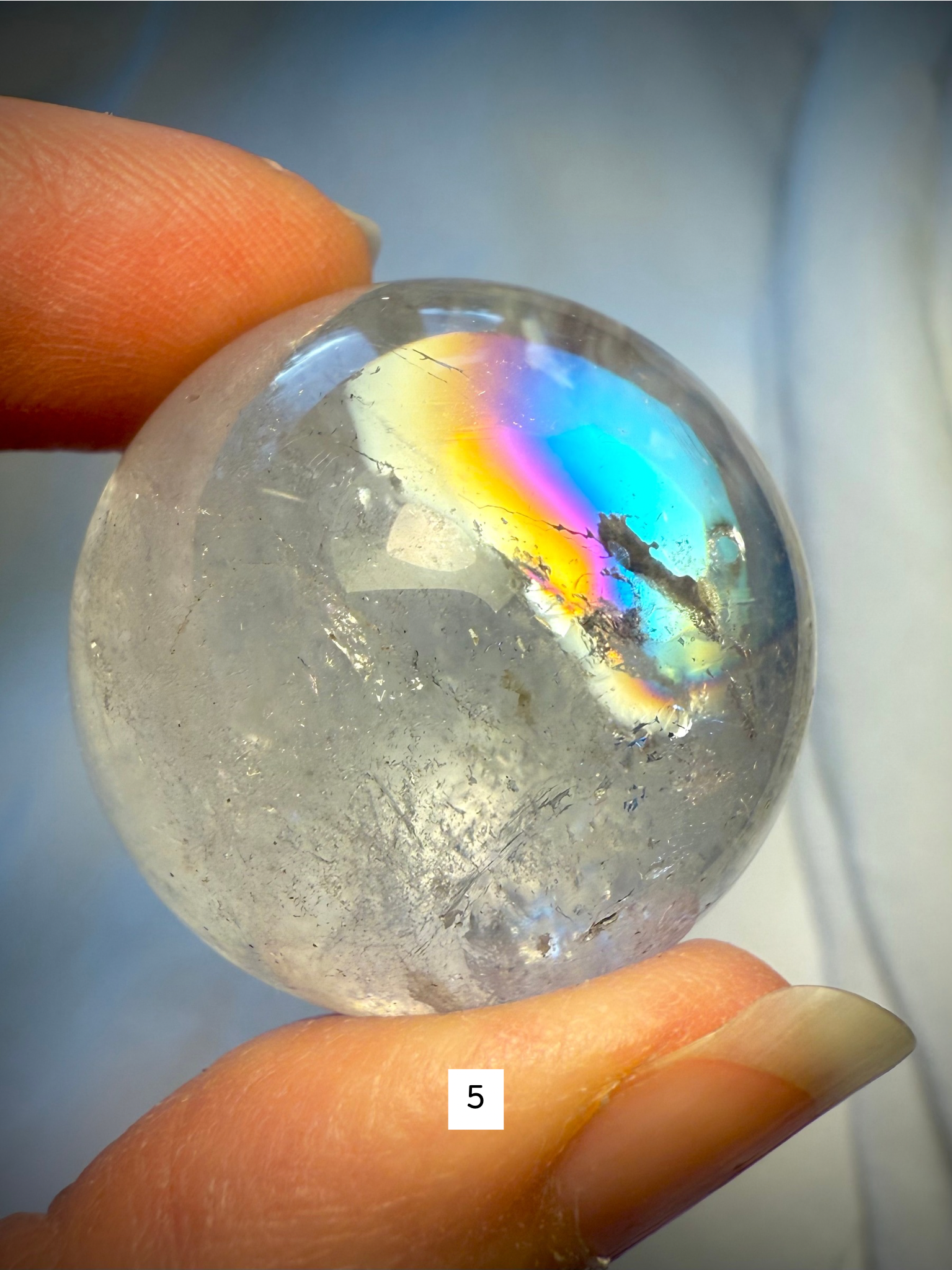 Crystal ball #5 with prismatic rainbows and icy inclusions, showcasing the beauty of Rainbow Quartz up close.