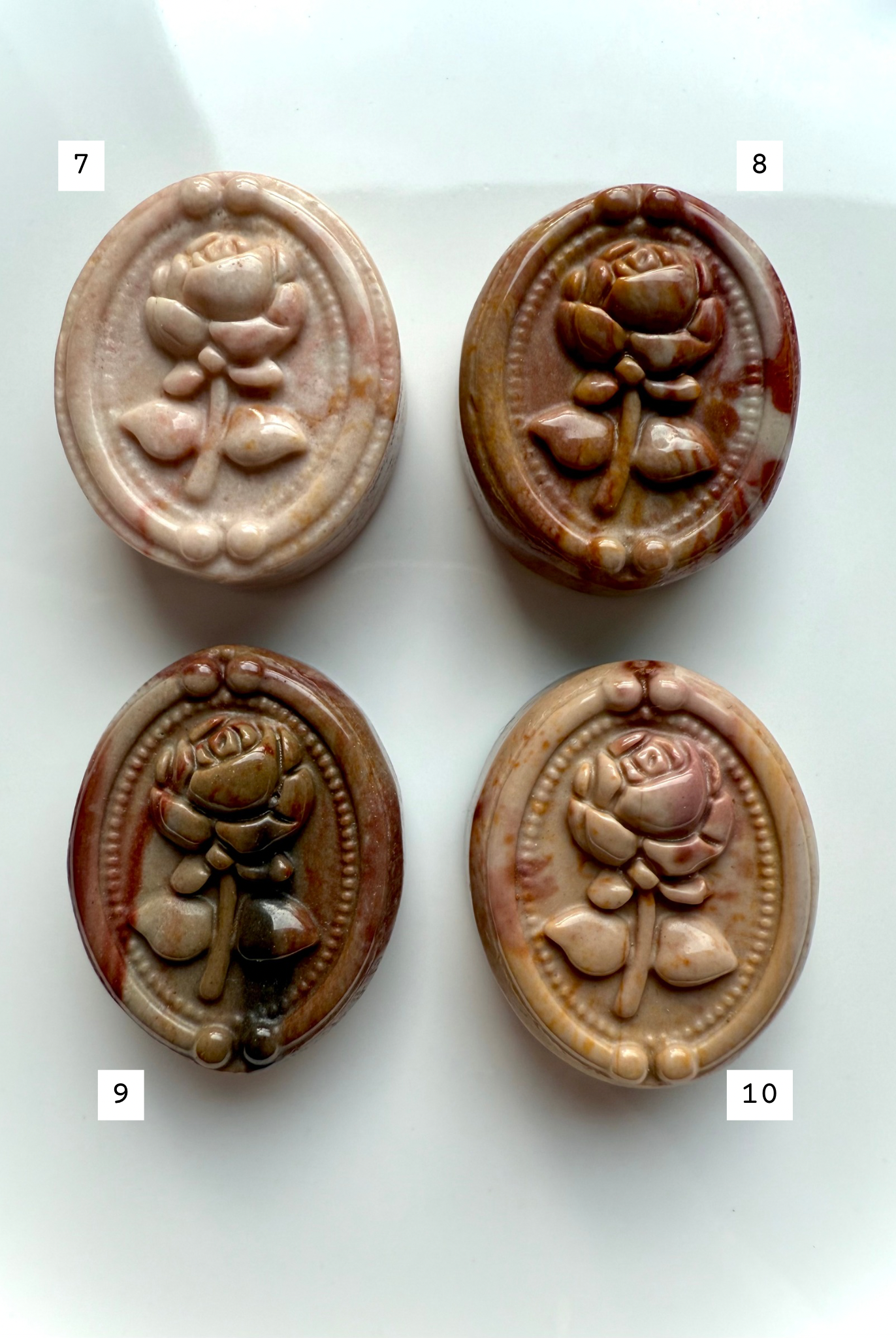 Polychrome Jasper rose carvings displayed in a four-piece arrangement — soothing earth-tone crystals for stability, comfort, and emotional grounding.
