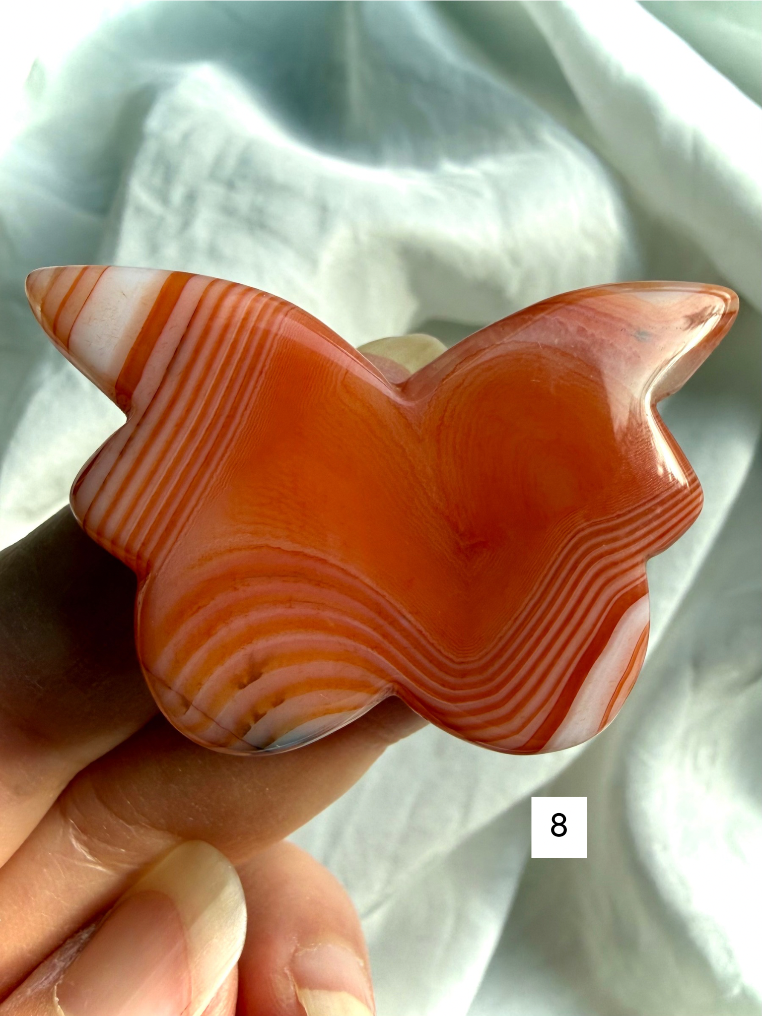 Carnelian butterfly crystal carving number 8 featuring layered amber, rust, and cream agate patterns in a polished butterfly shape