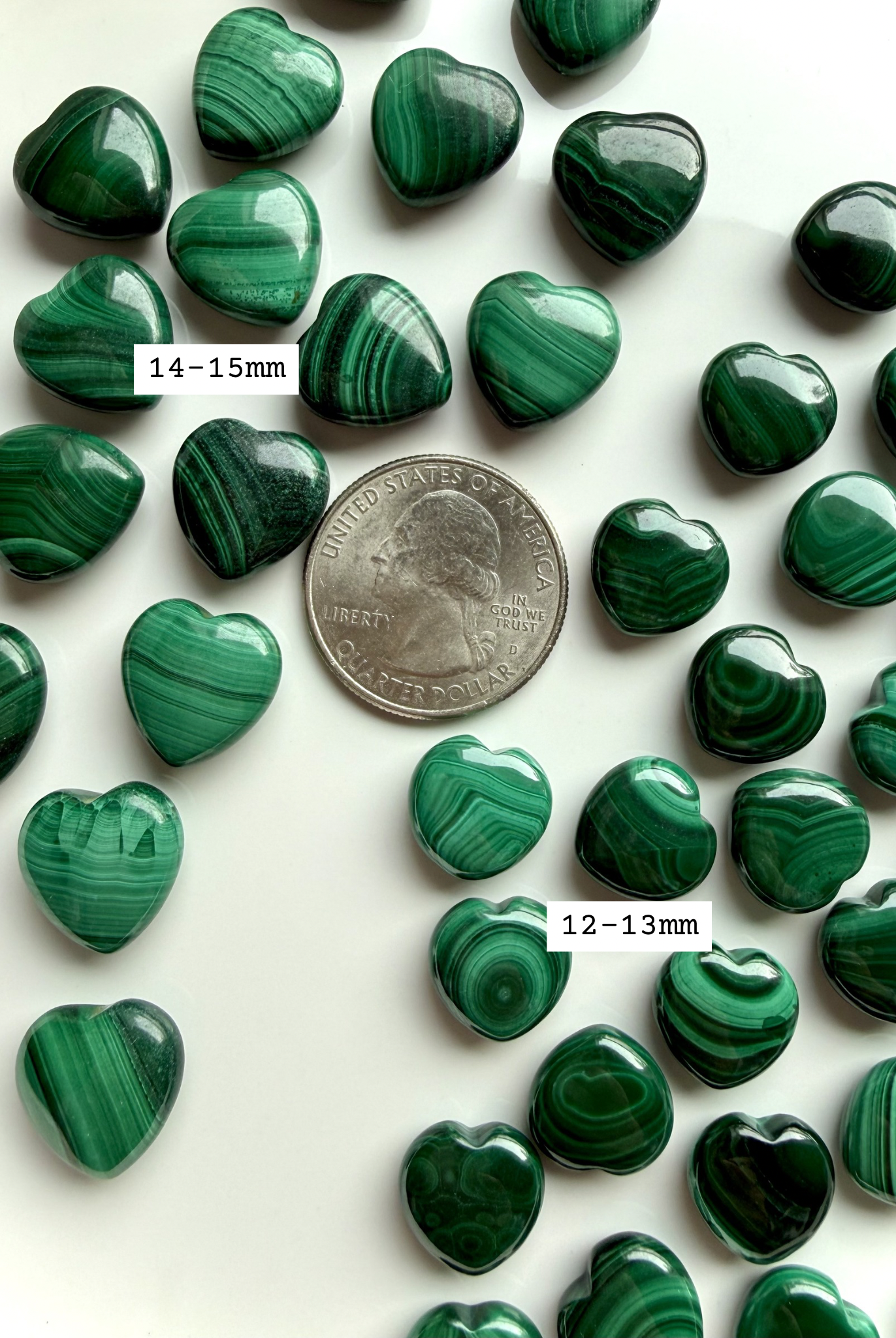Two sizes of mini malachite hearts arranged with a US quarter for size reference