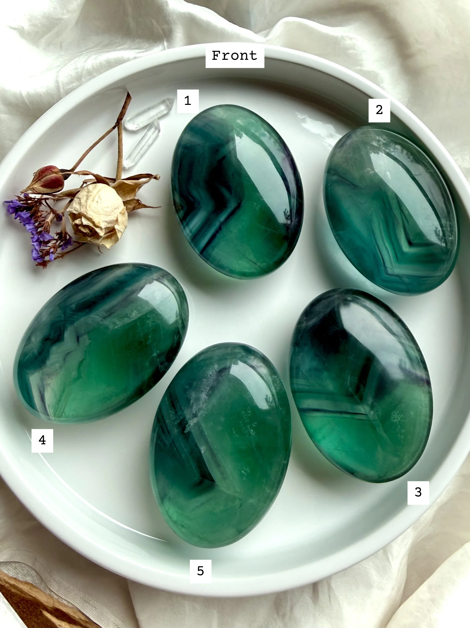 Front view of large teal fluorite palm stones labeled 1–5, displaying saturated blue green banding and natural internal movement