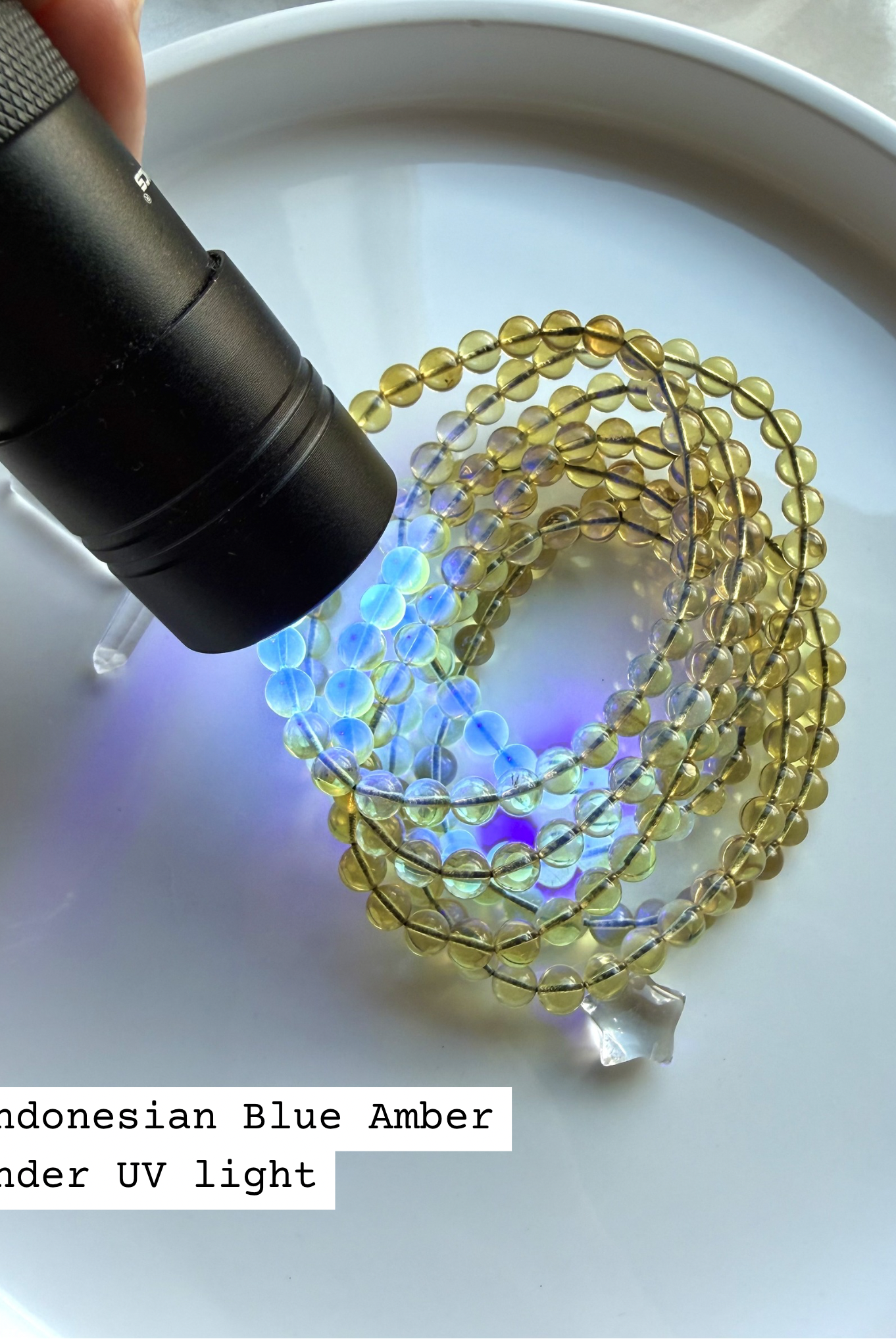 Indonesian blue amber bracelet glowing under UV light – UV reactive amber crystal bead bracelet