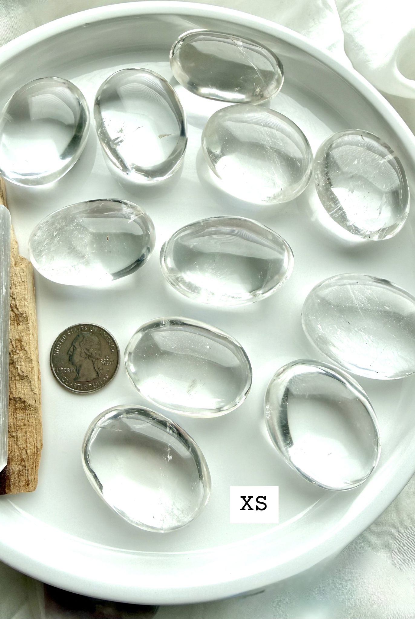 Clear quartz meditation stones, marked XS shown with a US Quarter for scale, smooth polished palm stones for energy work
