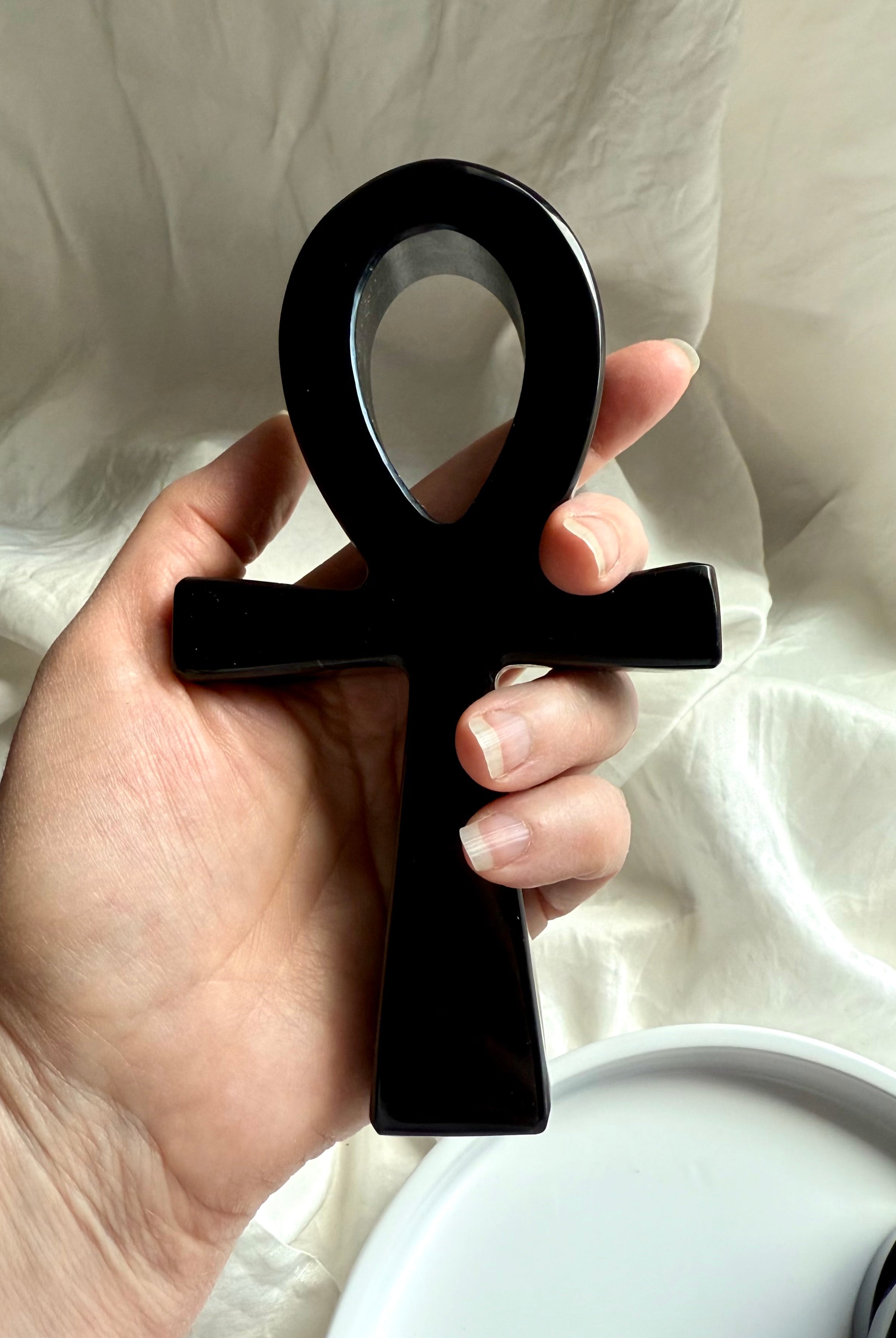 Hand-carved black obsidian ankh carving held in hand — sacred Egyptian crystal symbol of eternal life and protection.