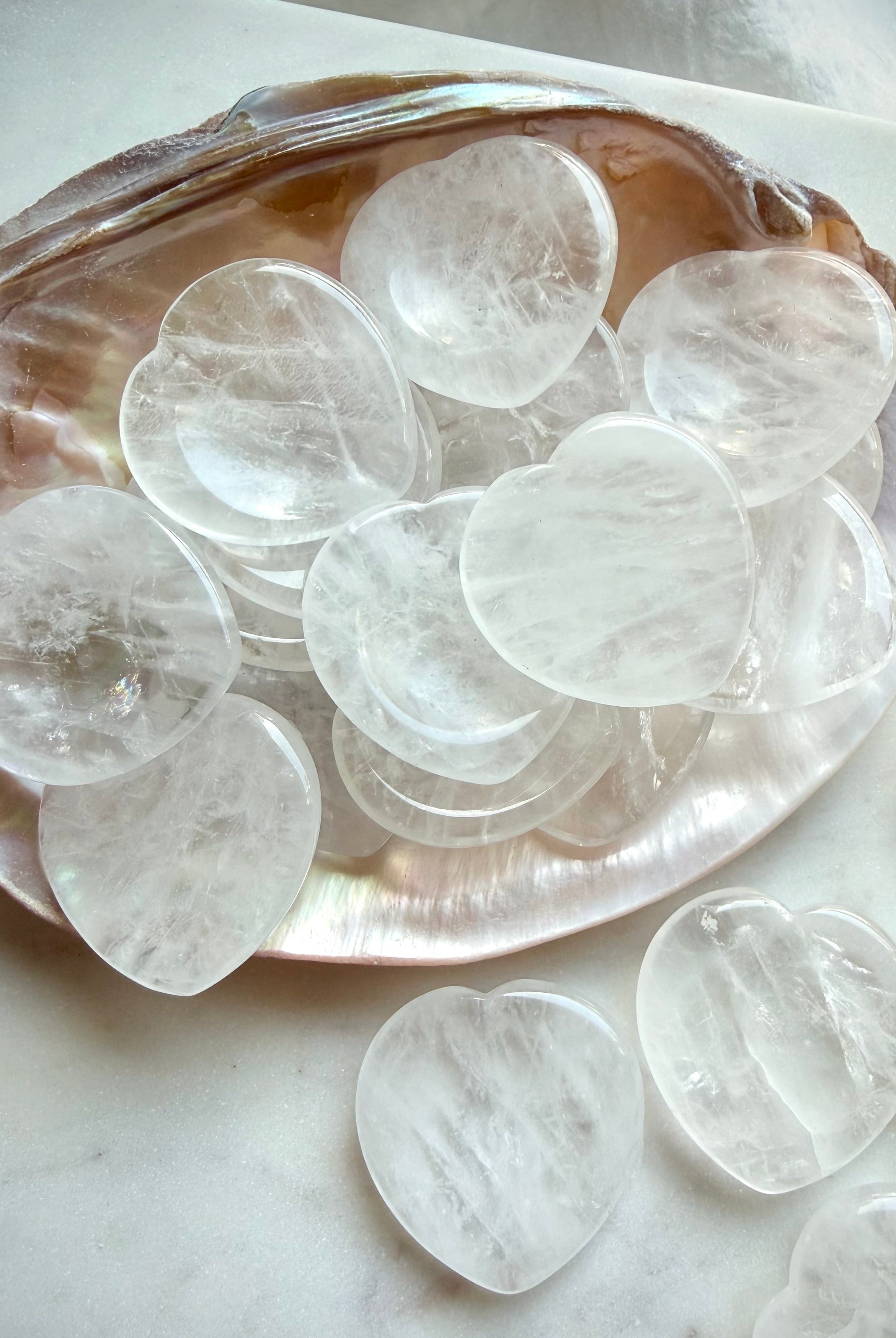 clear quartz worry stones arranged on shell dish for meditation clarity and healing energy