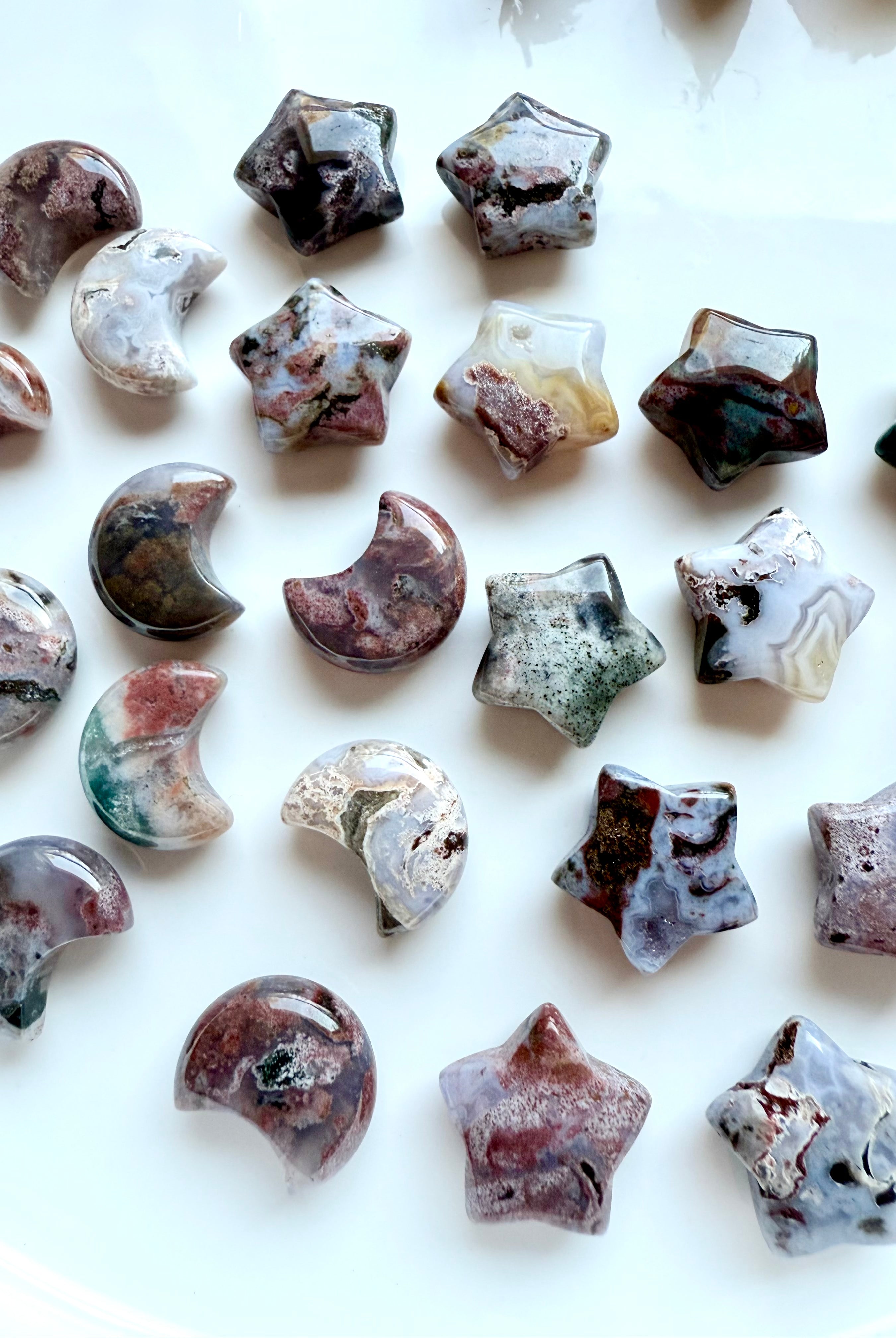 Close-up of mini Ocean Jasper stars and crescent moons with unique colors, patterns, and druzy details, crystal carvings for altar décor