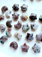 Close-up of mini Ocean Jasper stars and crescent moons with unique colors, patterns, and druzy details, crystal carvings for altar décor