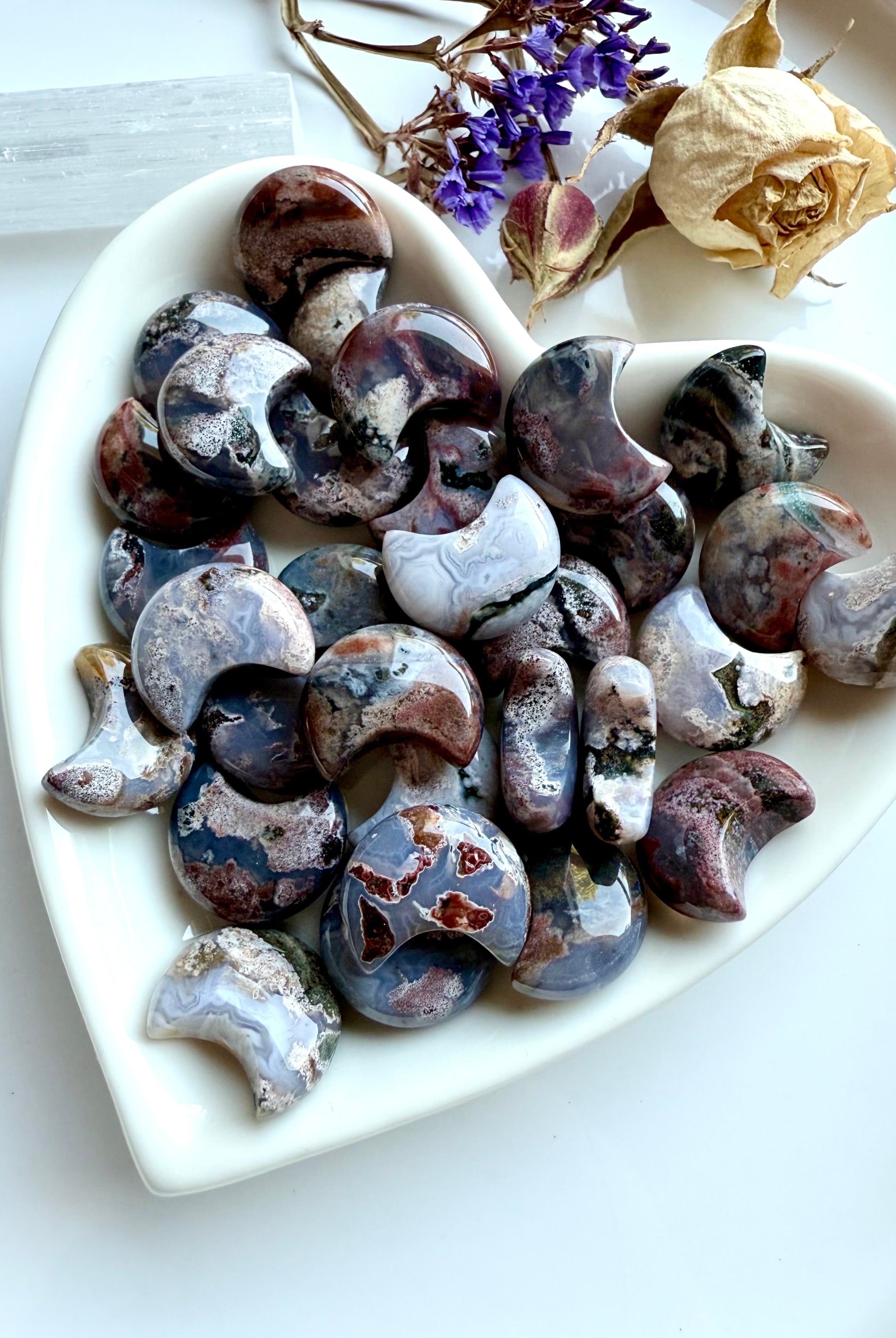 Heart-shaped dish filled with Ocean Jasper moons — mini crescent moon carvings with cosmic patterns for chakra healing and ritual use