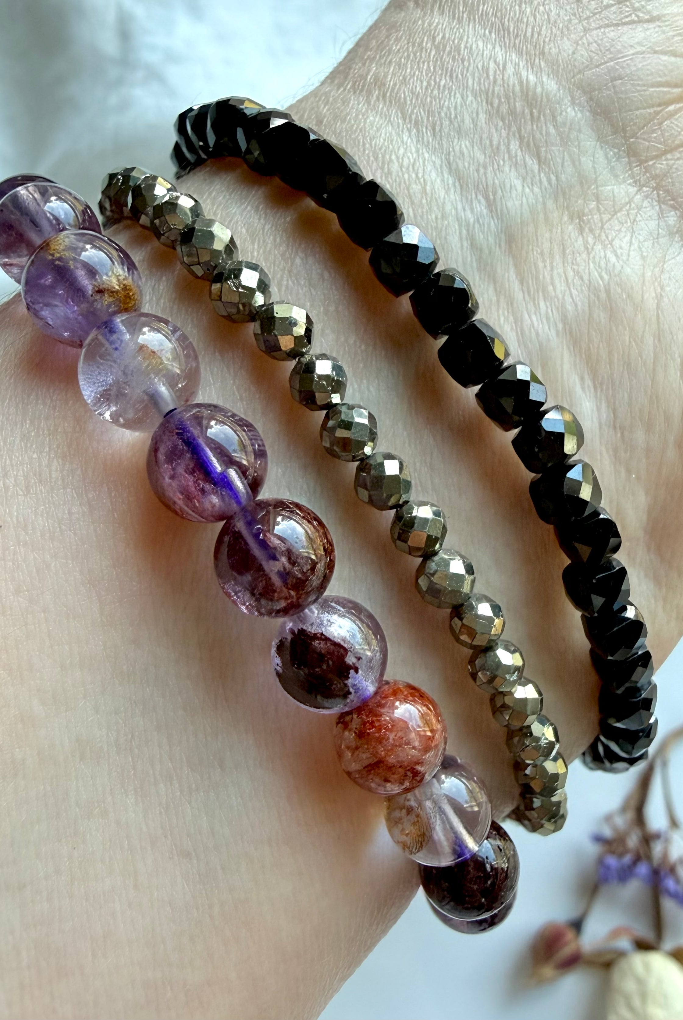 stacked crystal bracelets featuring Super Seven quartz, faceted Pyrite, and faceted Black Spinel for grounding, protection, confidence, and spiritual energy