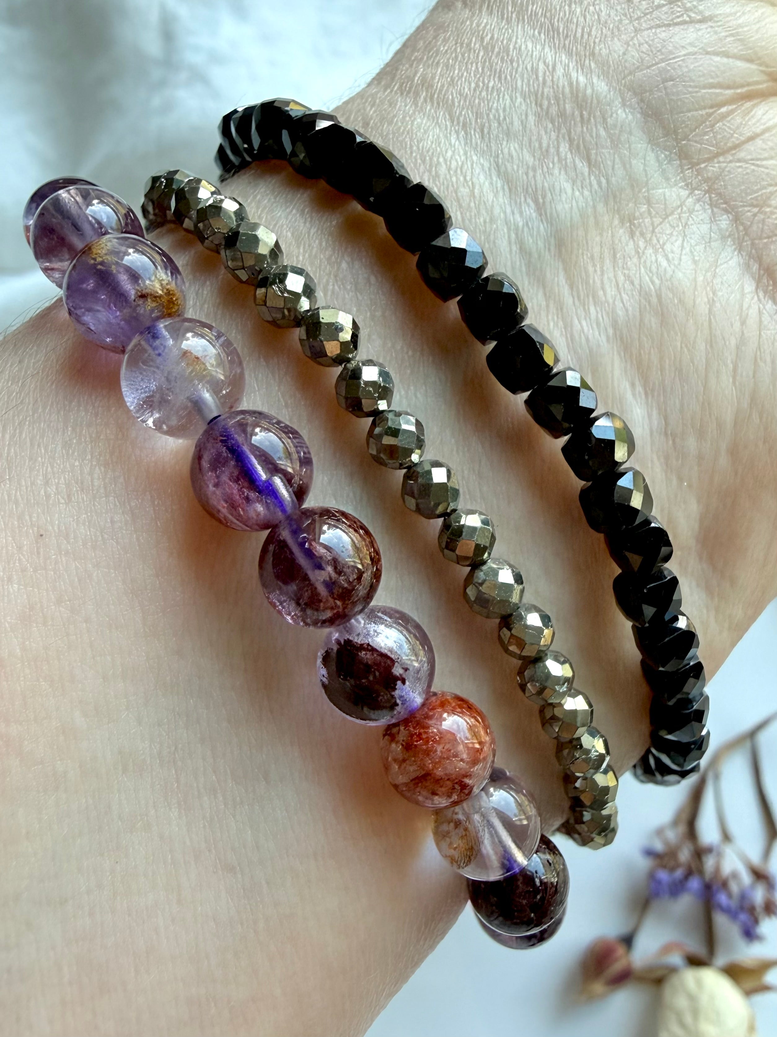 stacked crystal bracelets featuring Super Seven quartz, faceted Pyrite, and faceted Black Spinel for grounding, protection, confidence, and spiritual energy