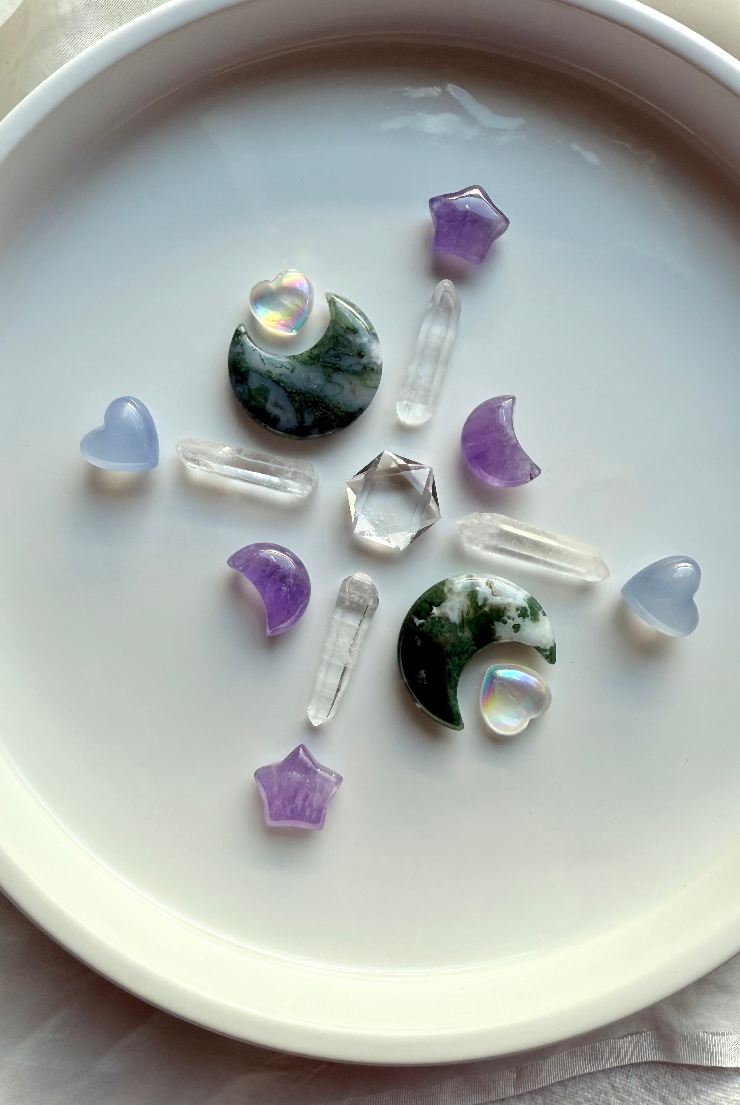 Moss Agate moons in a crystal grid with amethyst, aura quartz, and clear quartz points — soothing chakra healing stones for grounding rituals and Gaia energy.
