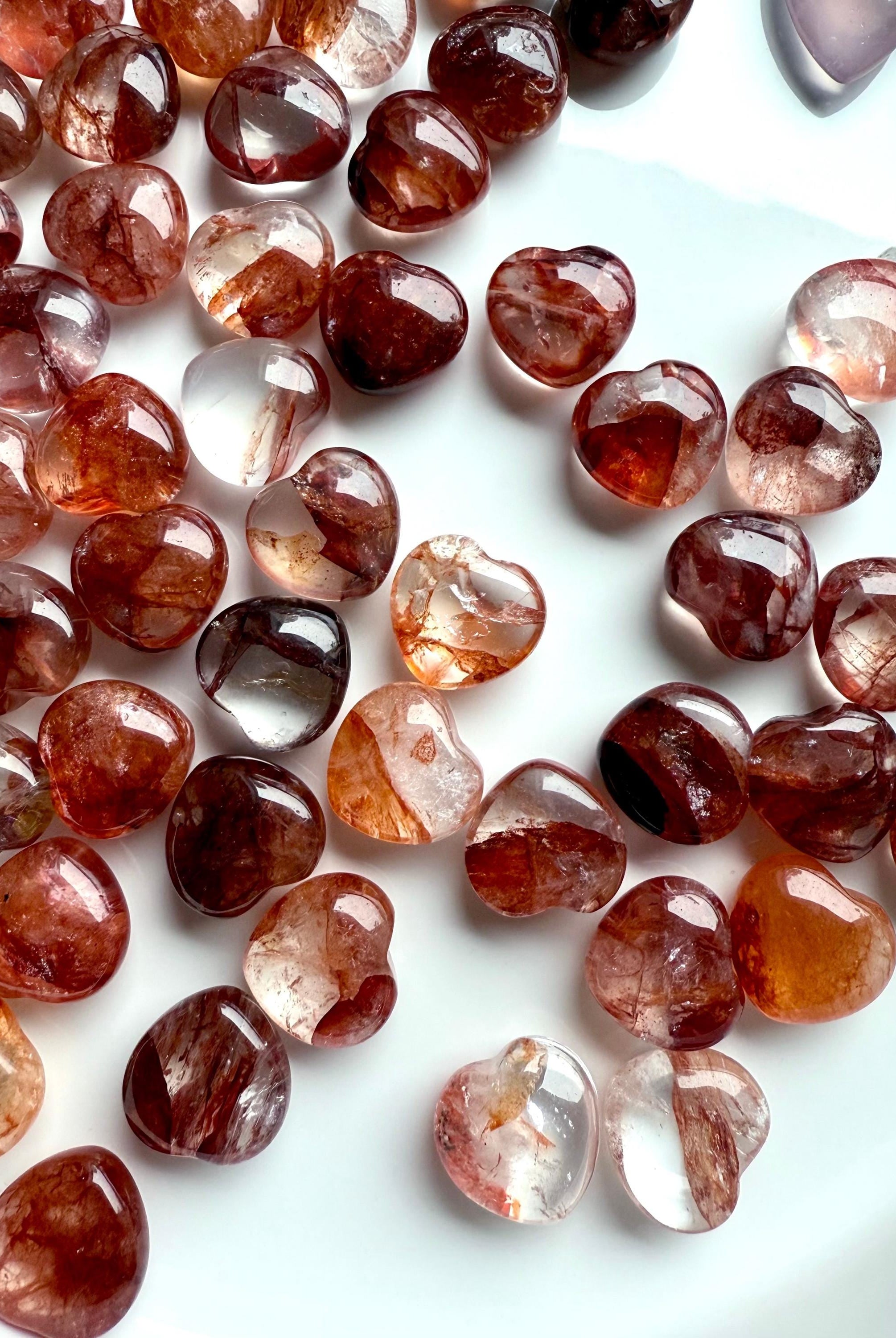 Gemmy Fire Quartz Crystal Hearts shown on a white plate, photographed in natural light