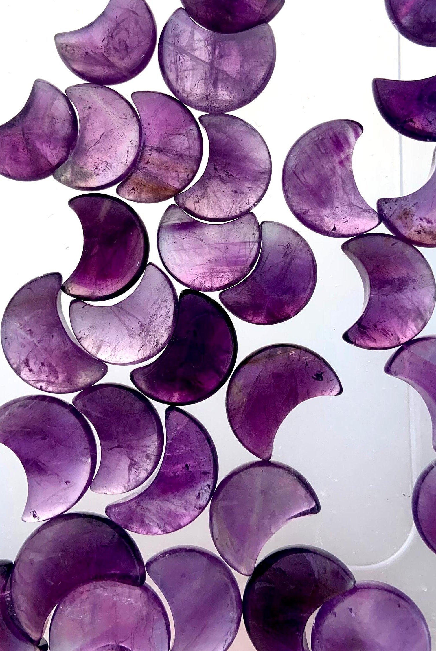 Mini amethyst moons on a translucent background to highlight the clarity & quality of the crystal