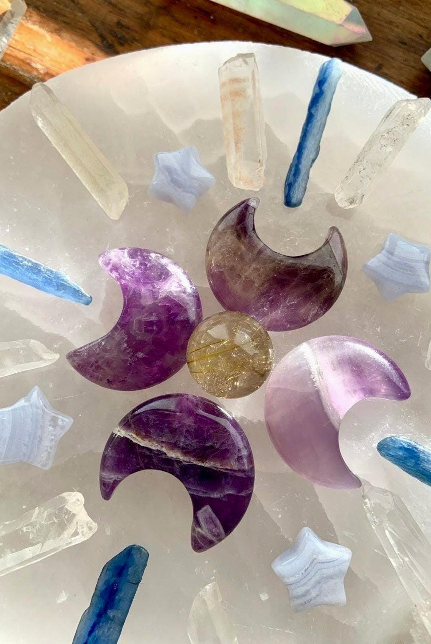 A Crystal Grid with Dream Amethyst Crescent Moon carvings and several other crystals from our shop