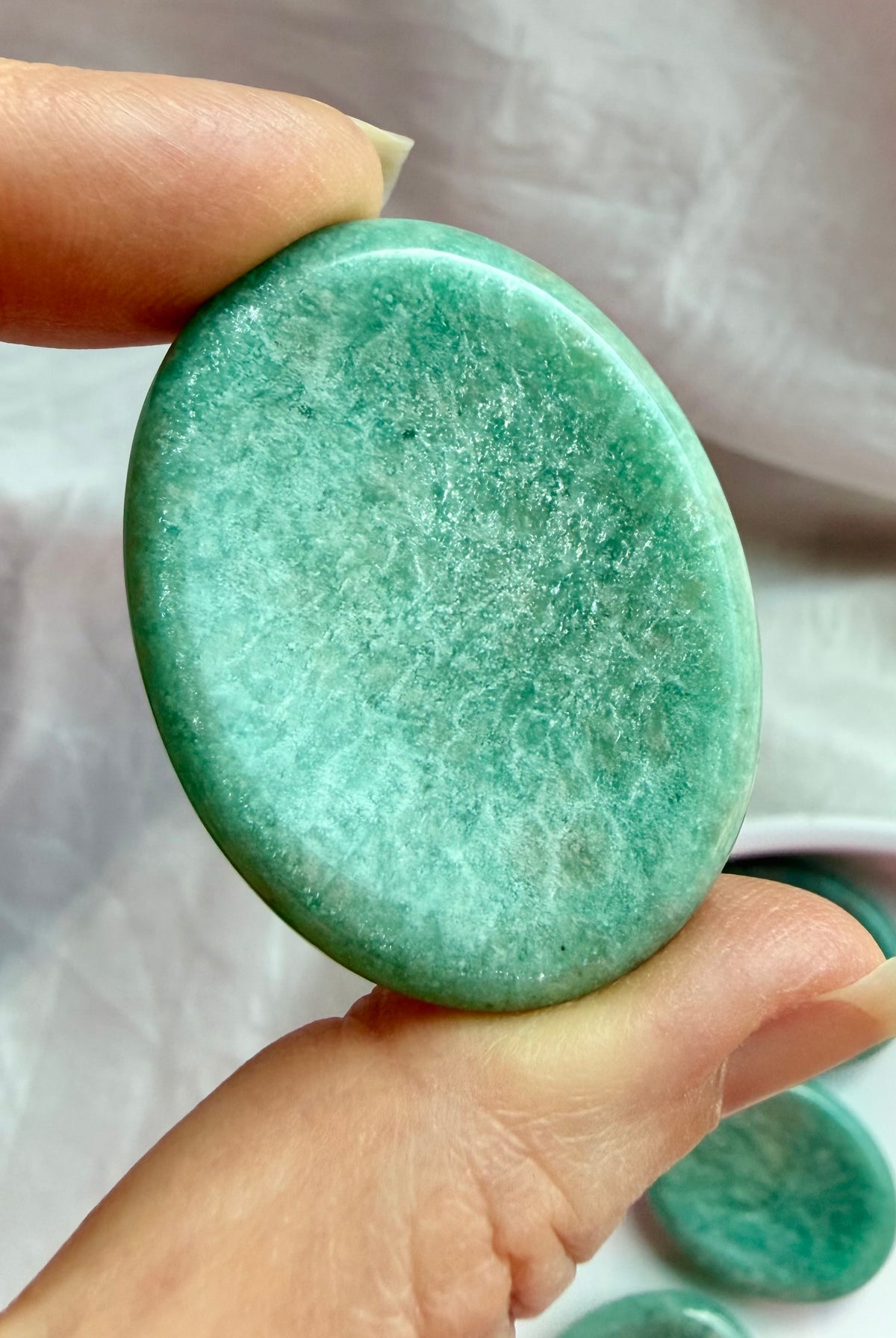 Close-up of Amazonite thumb stone revealing vibrant seafoam-green tones, natural mineral patterns and a gently curved thumb indentation