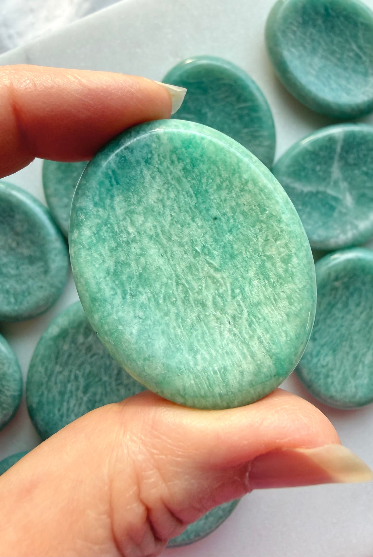 Amazonite worry stone shown close-up with natural color variations and smooth polished thumb indentation for calming meditation rituals