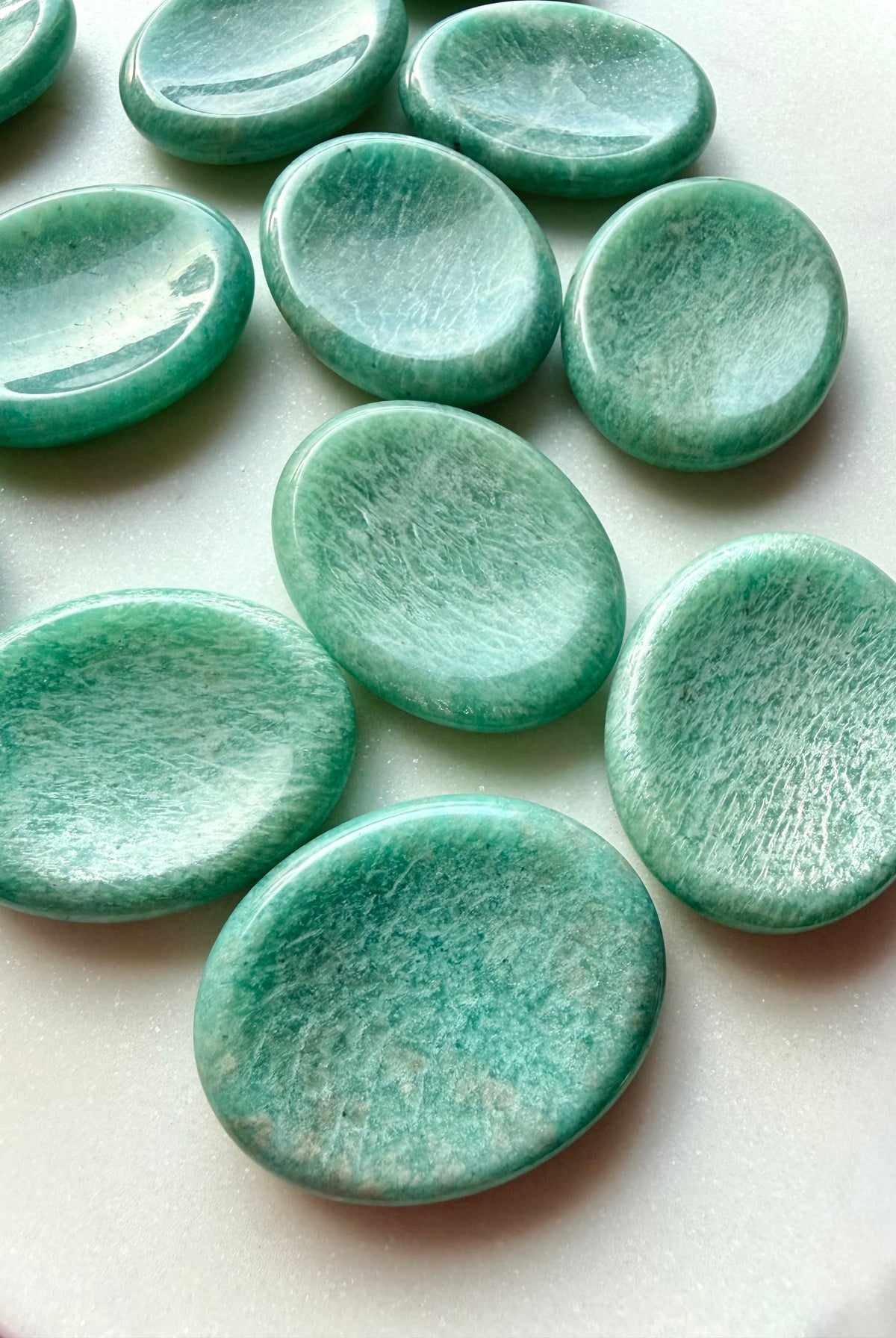Polished Amazonite worry stones arranged together, calming green healing crystals for stress relief, meditation and emotional balance