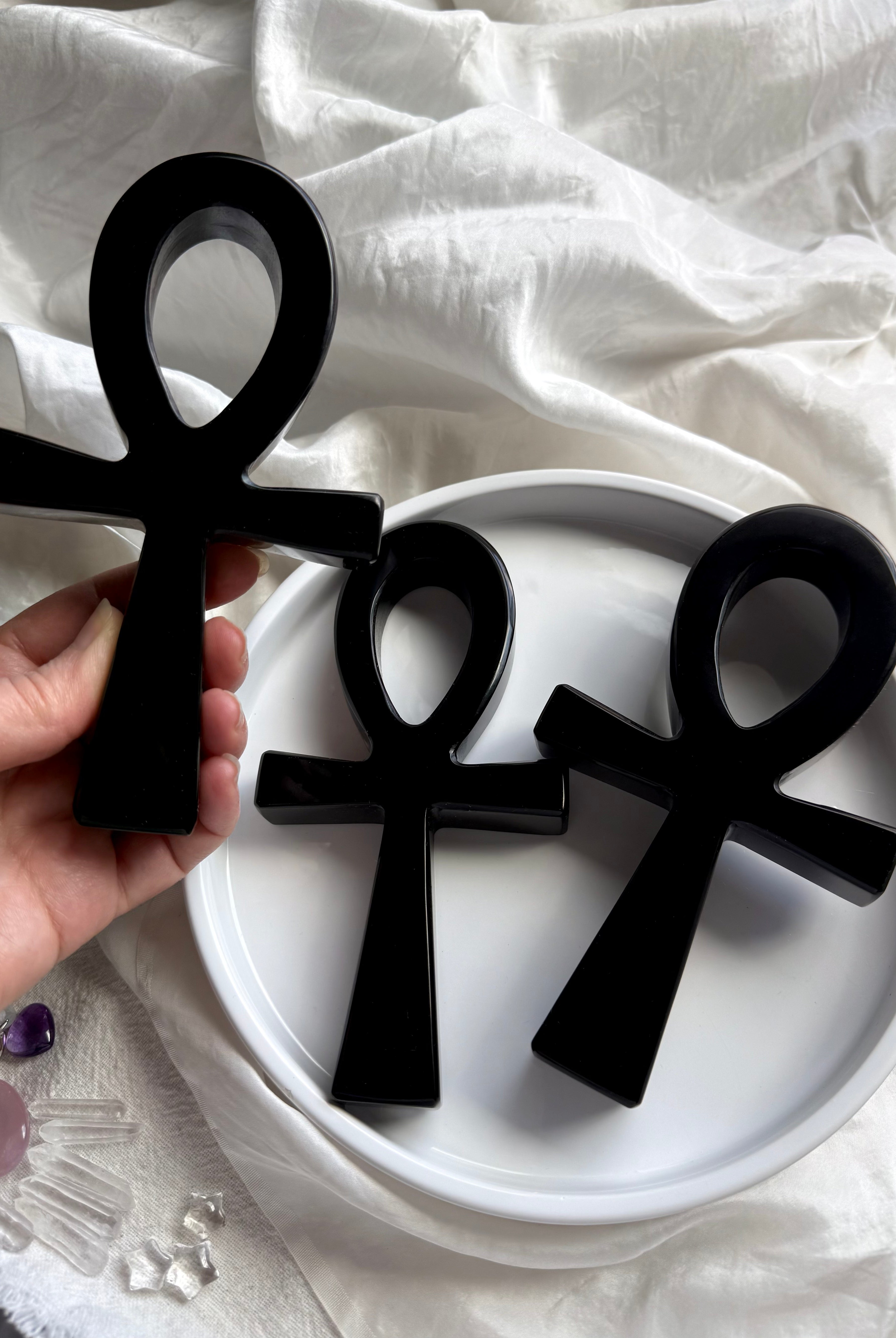 Three black obsidian ankhs displayed together — carved crystal ankhs for spiritual practice and sacred symbolism.