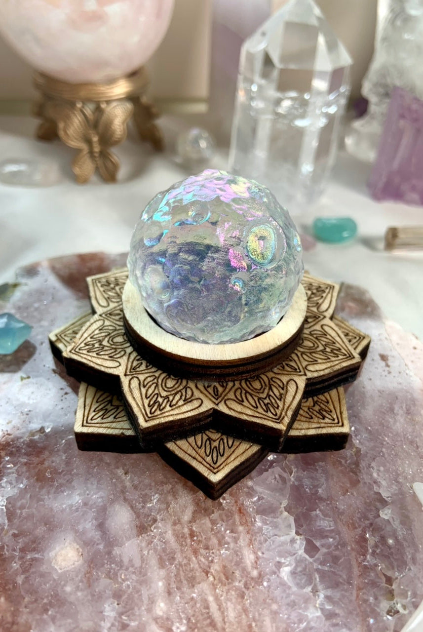 Angel Aura Full Moon crystal sphere on wood lotus stand atop a pink amethyst slab, surrounded by dreamy celestial crystals — radiant display decor.