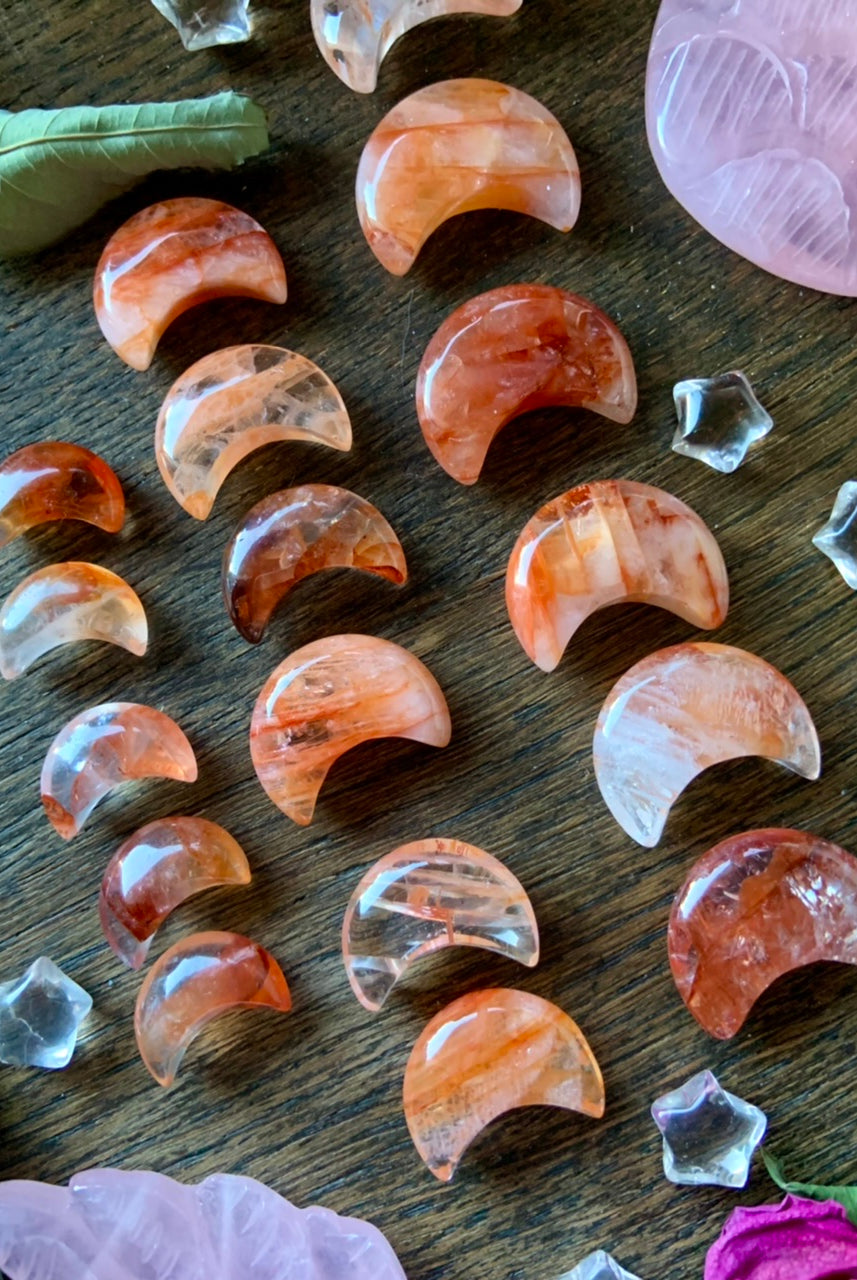 Fire Quartz with Golden Healer Moons, on a dark wood background set in graduated size rows