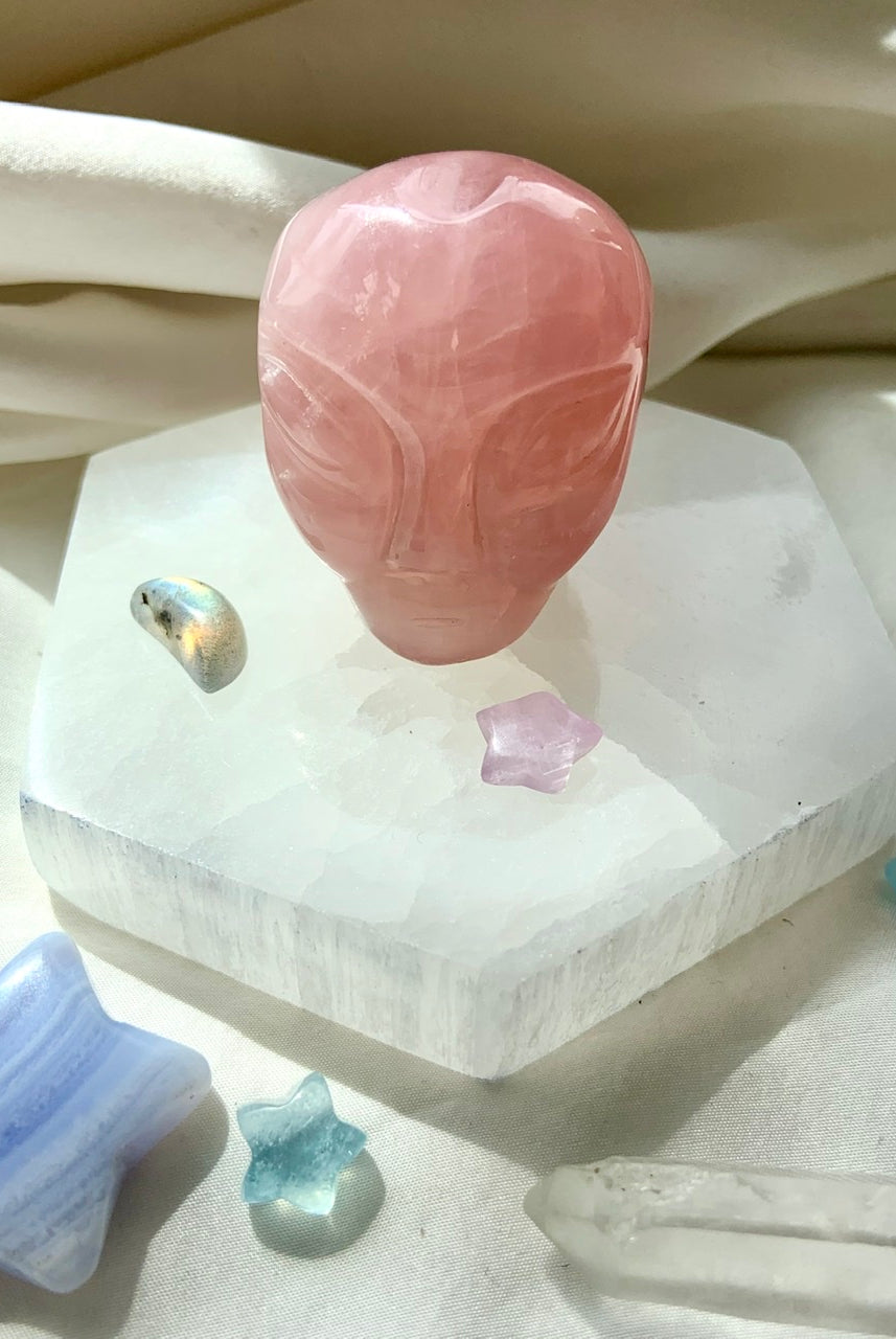 Rose Quartz alien head carving displayed on hexagon selenite plate with crystal stars – heart chakra healing crystal for cosmic love
