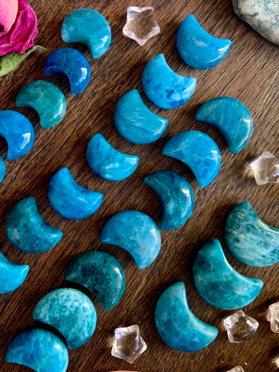 Diagonal arrangement of Blue Apatite Crescent Moons with quartz stars — mini moon-shaped crystals in size order for truth & self-expression.