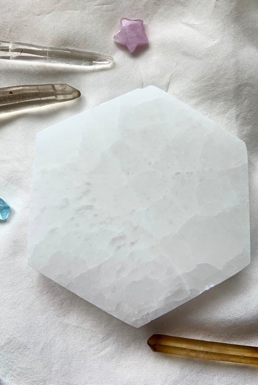 Overhead view of a Selenite Hexagon Charging Plate with clear quartz points, citrine points, and mini crystal stars