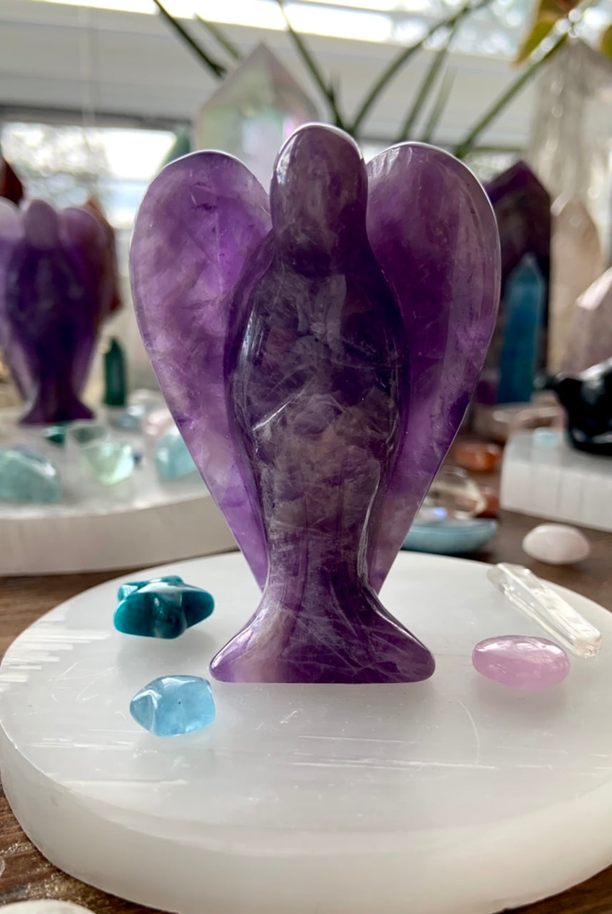 Selenite plate used as altar base for amethyst angel carving with mini celestial crystal accents