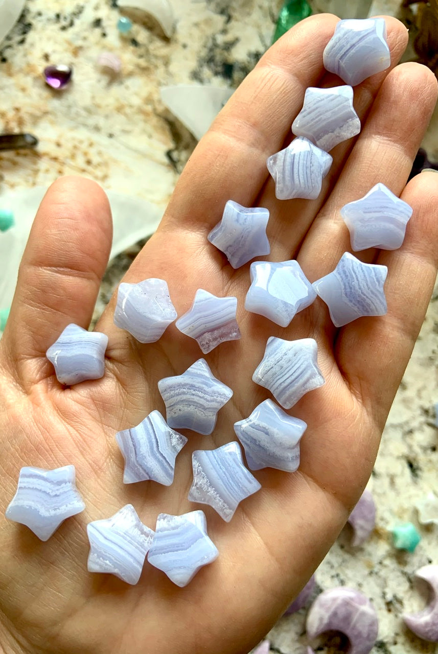 Mini Blue Lace Agate stars on hand for scale — soothing crystals for communication, clarity & emotional healing