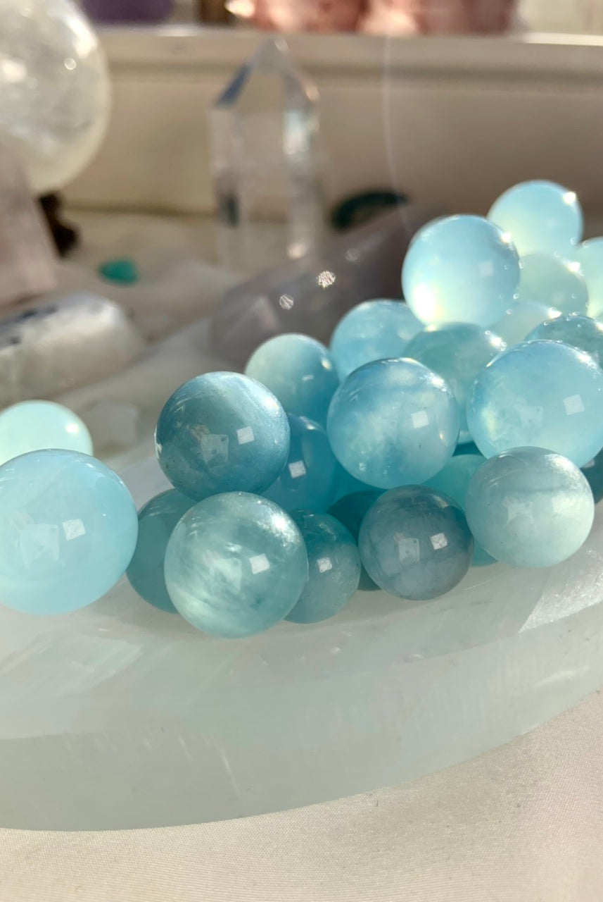 Aquamarine mini crystal spheres arranged in crescent shape – blue March birthstone spheres