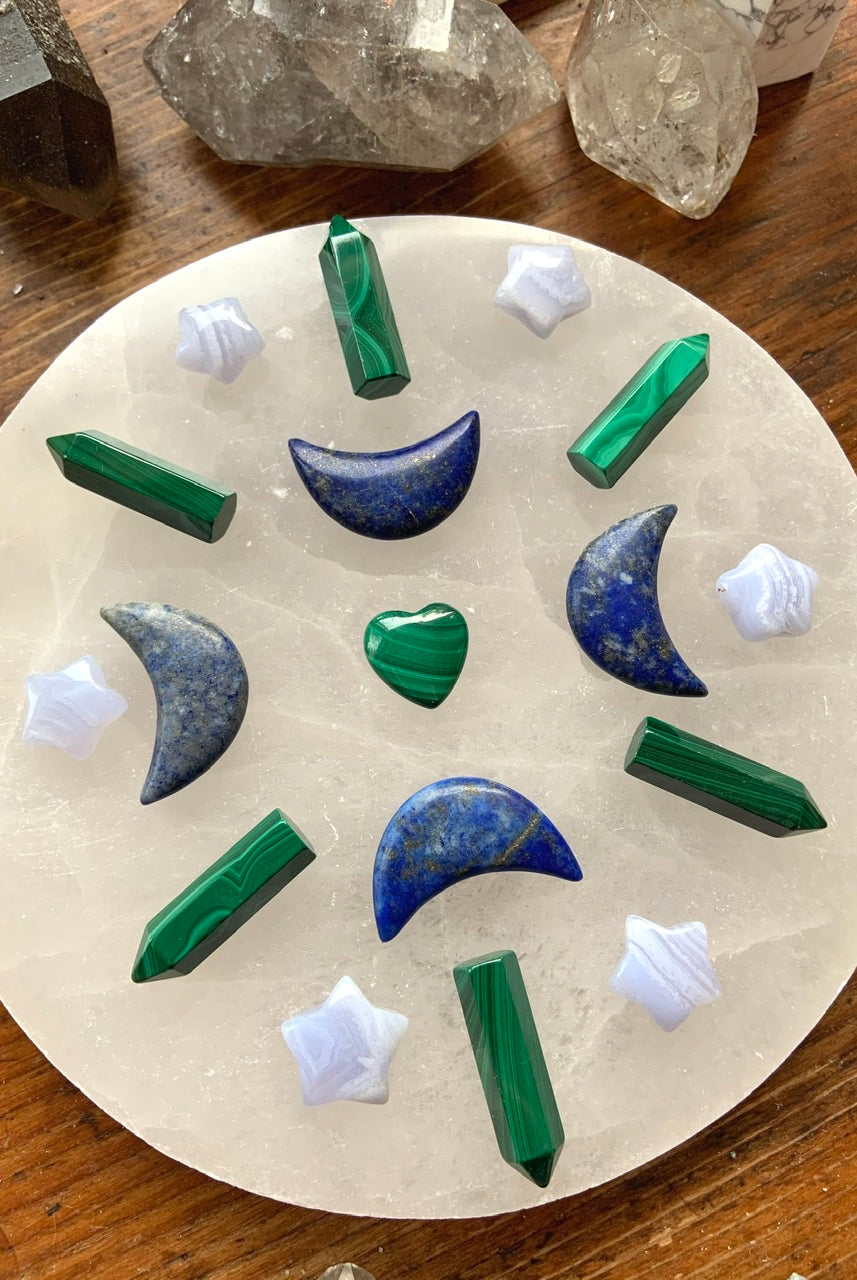 Blue Lace Agate stars in a crystal grid with Malachite points & Lapis Lazuli moons on a selenite plate — high-vibe tools for clarity, balance & expression.