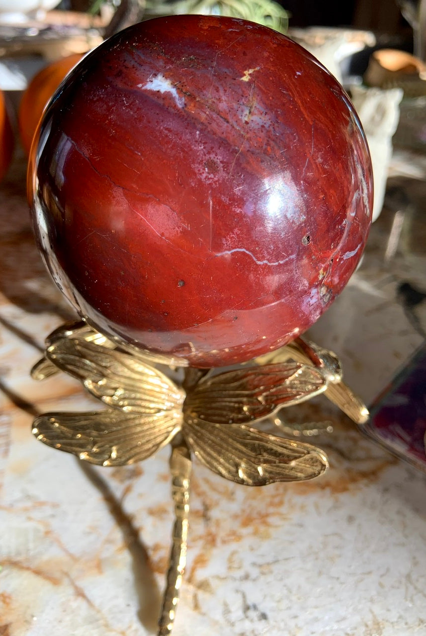 Gold dragonfly crystal ball stand holding a red ocean jasper sphere — unique holder for crystal sphere display.