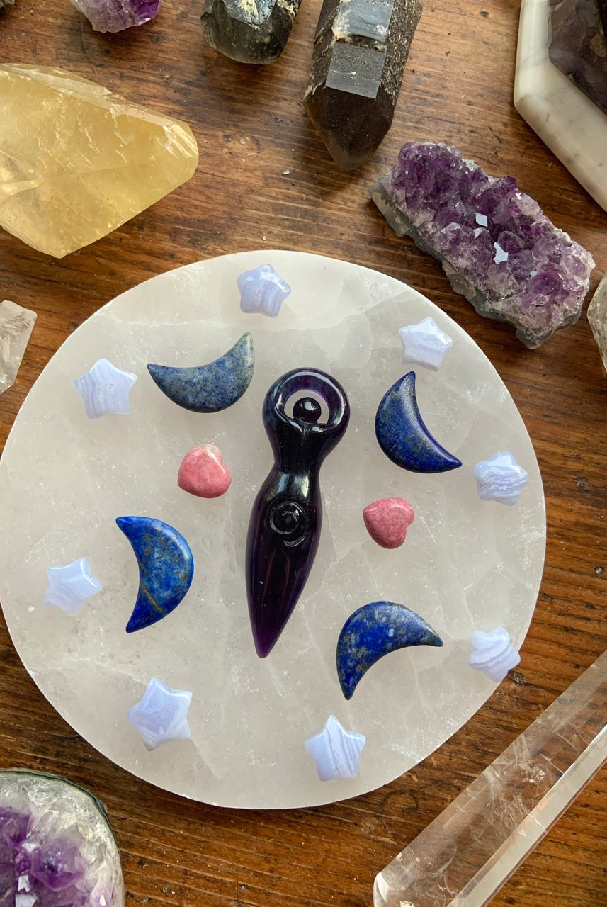 Crystal grid with Blue Lace Agate stars, moon carvings, & a goddess carving in the center — sacred layout for emotional healing & divine alignment.
