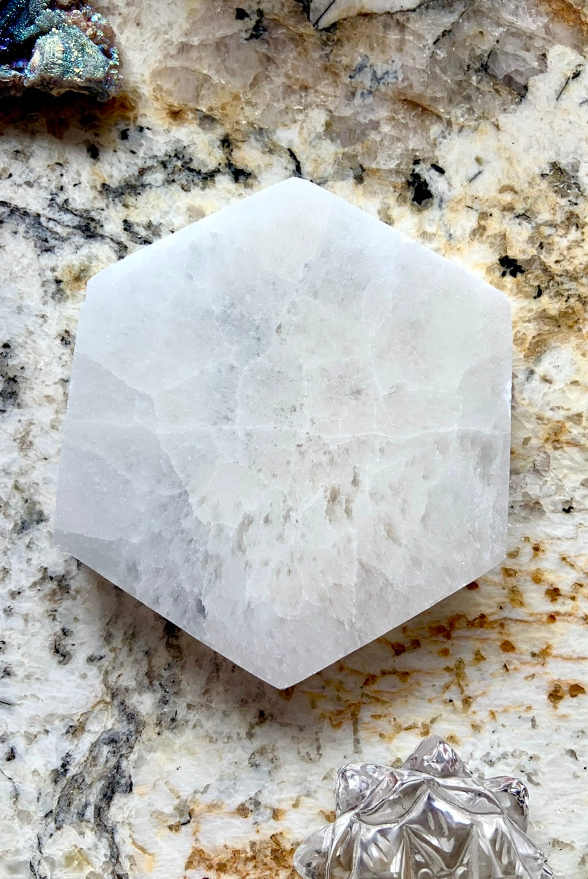 Overhead view of Selenite Hexagon Charging Plate on granite background for altar or chakra energy cleansing