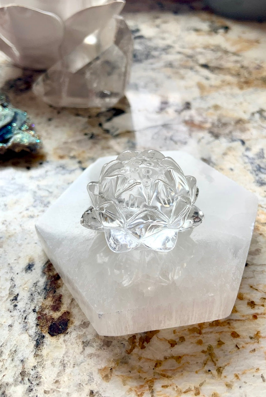 Side view of polished Selenite Hexagon Charging Plate with clear quartz lotus carving placed on top