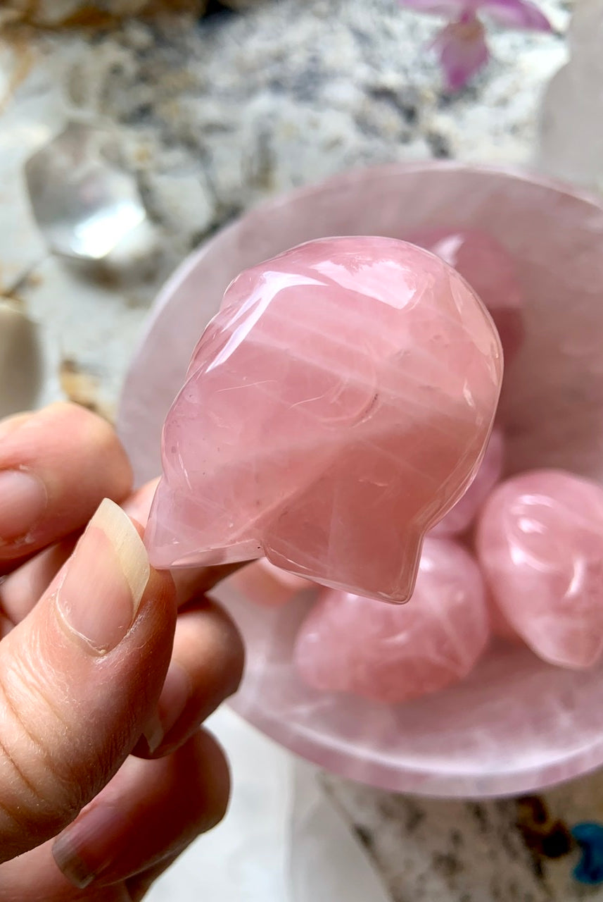 Side view of carved Rose Quartz alien head crystal with smooth finish and curved detail