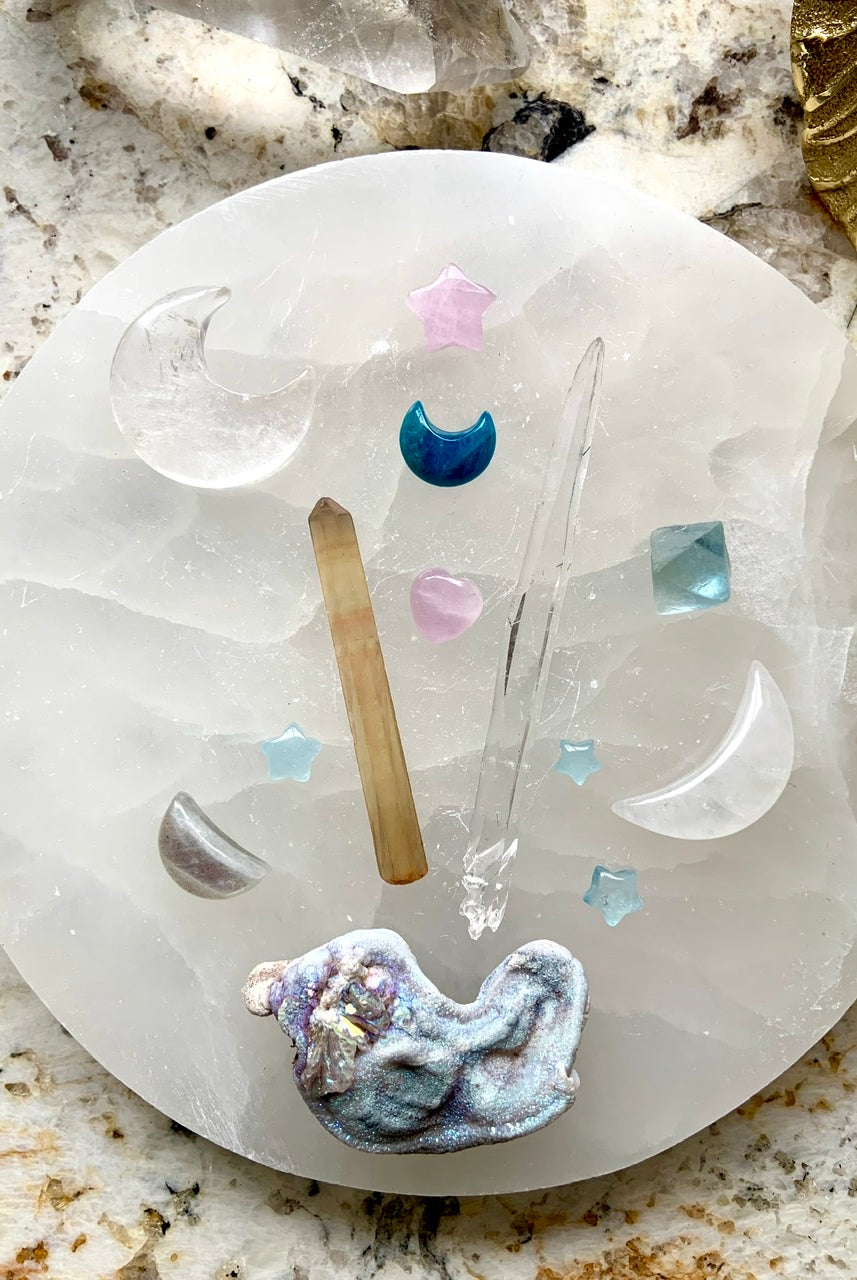 Celestial crystal grid with quartz moons, quartz points & aura druzy on a selenite plate — sacred energy setup featuring Blue Apatite for clear communication & healing.