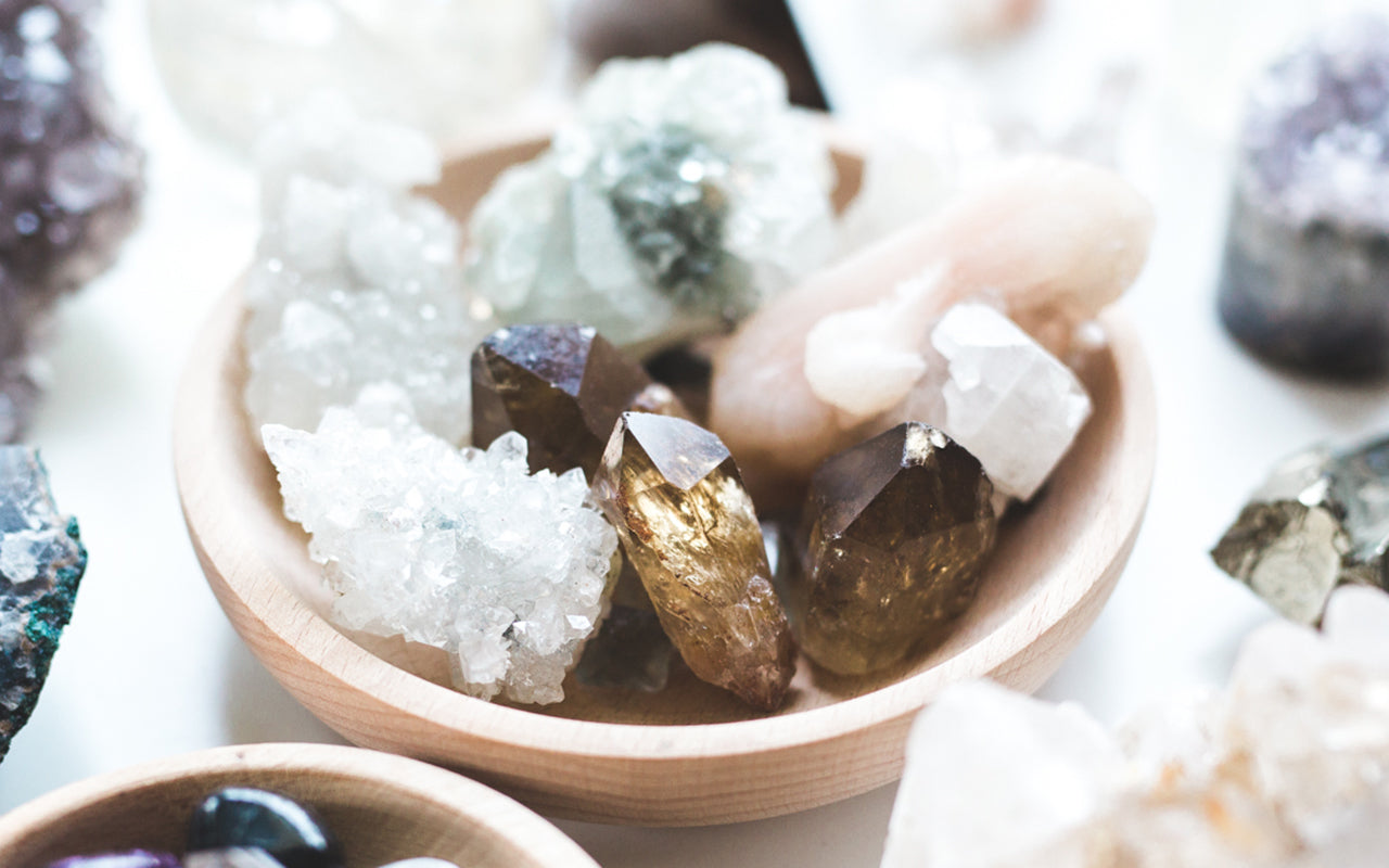 Healing crystals for nervous system regulation arranged in a wooden bowl with Smoky Quartz points and Clear Quartz clusters