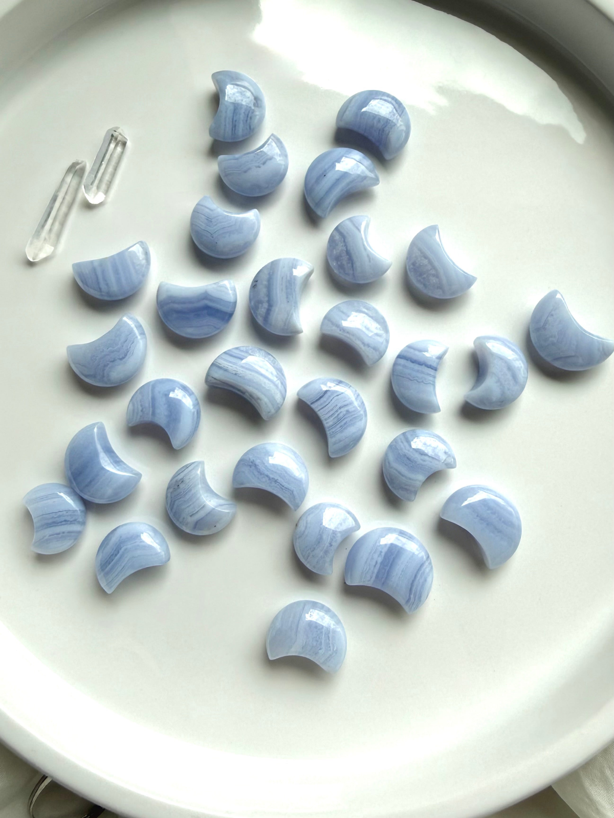 Blue Lace Agate crystal collection featuring polished crescent moon carvings with soft blue color and natural white lace banding