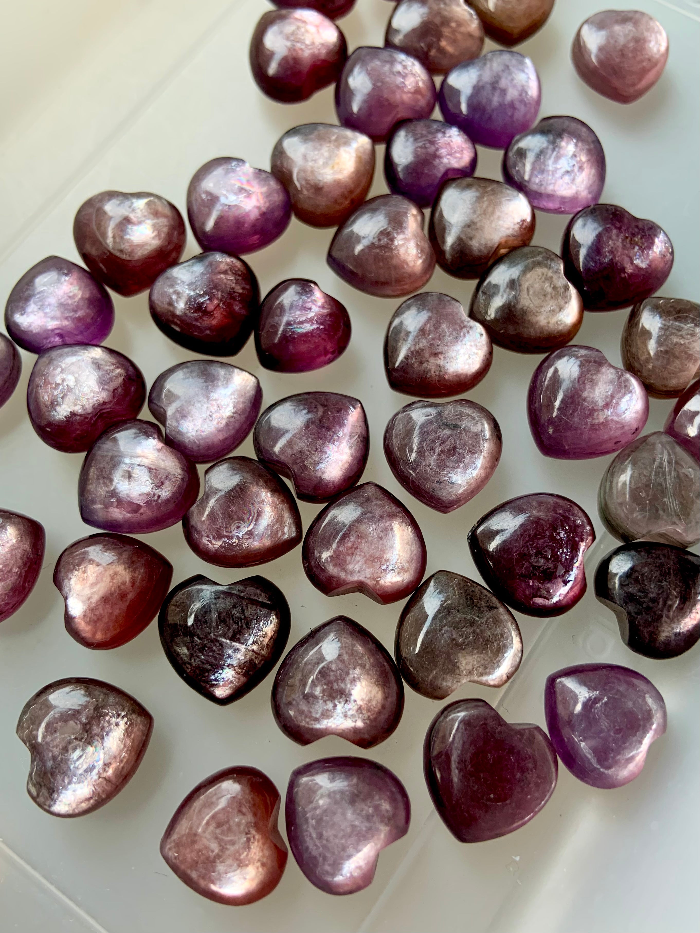 an array of mini Gem Lepidolite Hearts in flashy purple, violet and pink colors
