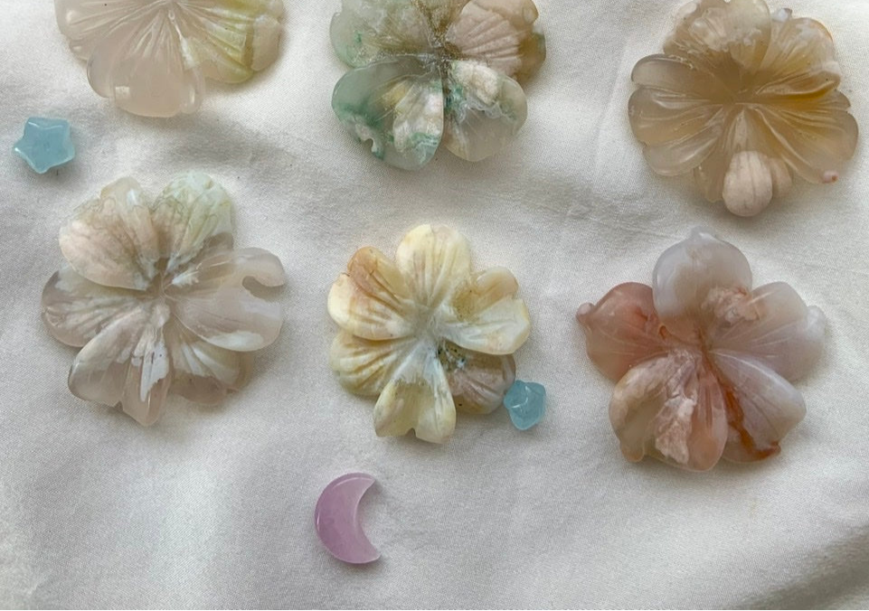 Flower Agate crystal flower carvings with intricate natural patterns in soft pink, cream, and green tones — nature-inspired gemstone art for collectors and plant lovers.