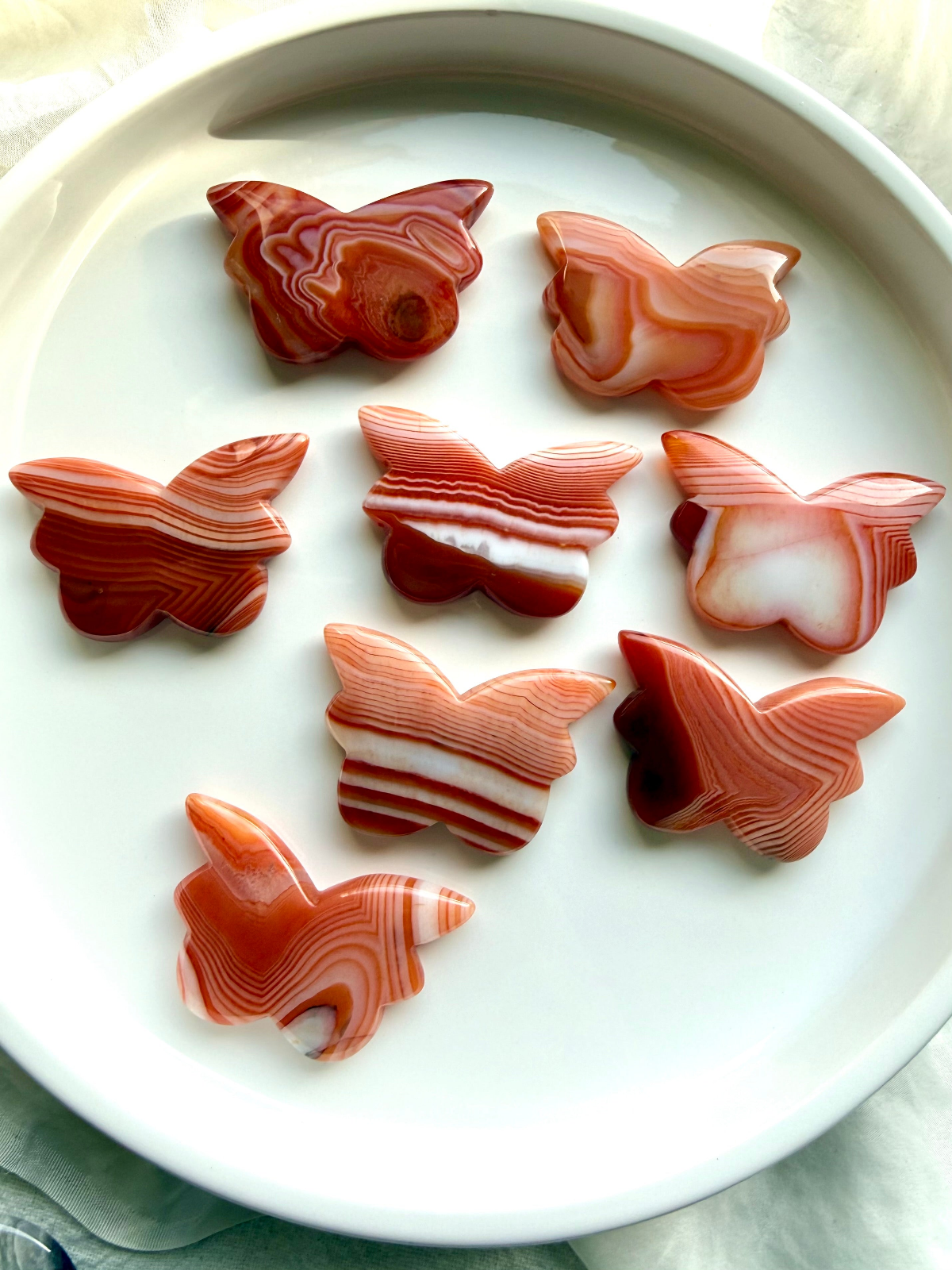 Carnelian crystal butterflies with orange, red and white banding, energizing stones for creativity, confidence, passion and vitality