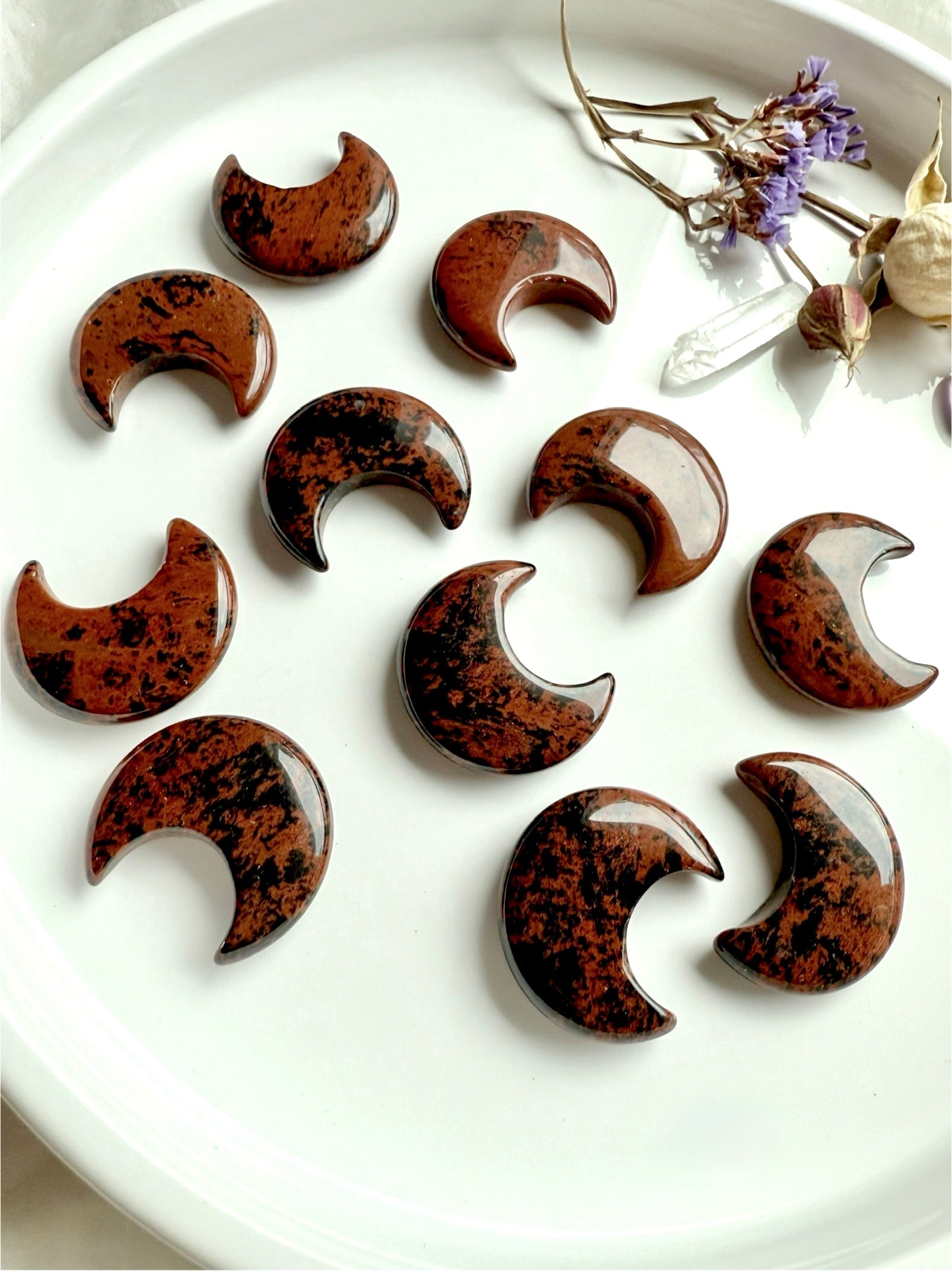 Array of Mahogany Obsidian crescent moons showing rich red-brown & black patterns. Root + Sacral Chakra crystals from Mexico for grounding, protection, and resilience.