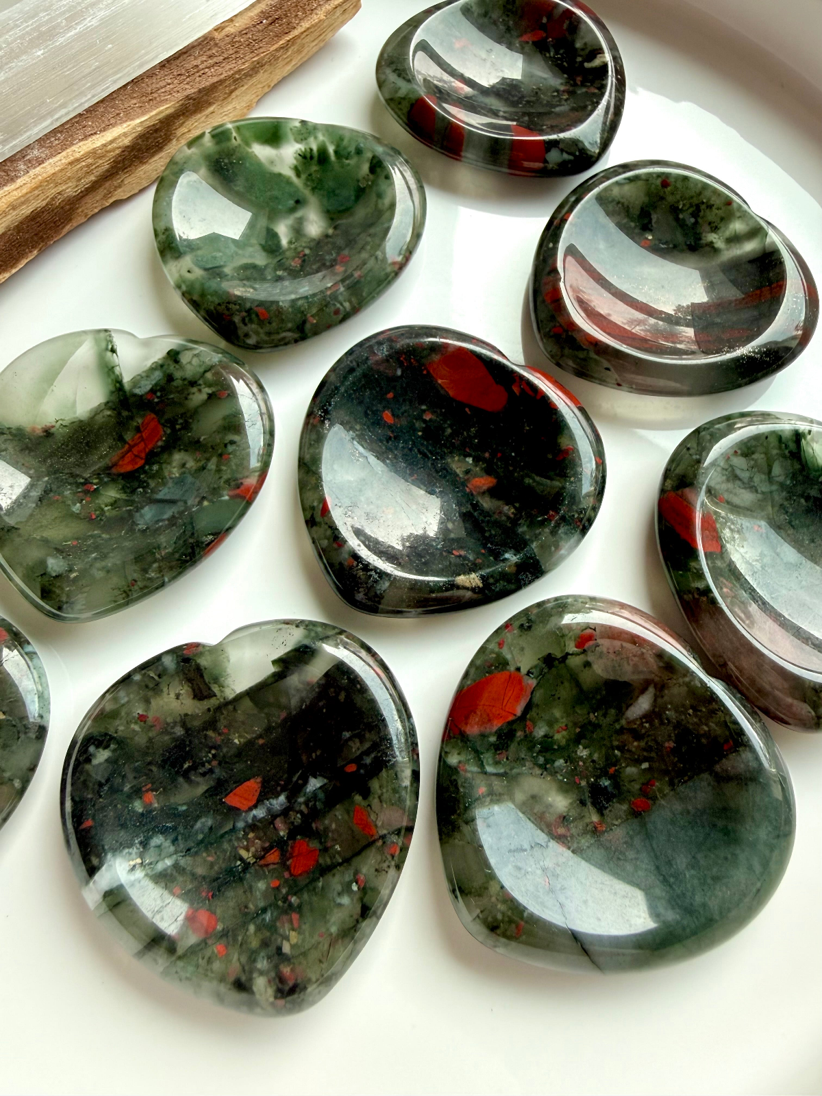 Bloodstone crystal collection featuring polished Bloodstone hearts and palm stones for courage, strength, vitality, and grounding