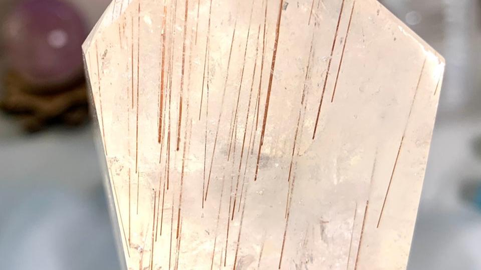 Close-up of a Copper Rutilated Quartz crystal featuring shimmering vertical rutile threads — a high-vibration healing stone with radiant inclusions.