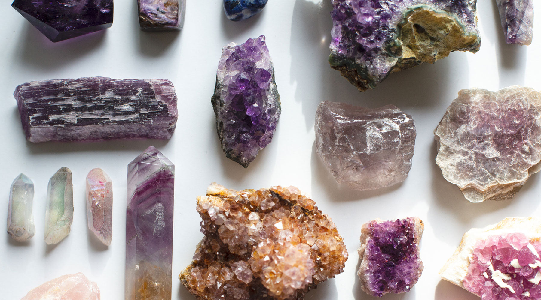 Purple Crown Chakra crystals including Amethyst, Lepidolite, Spirit Quartz, Fluorite, and Aura Quartz in a flatlay grid – spiritual stones for divine connection.
