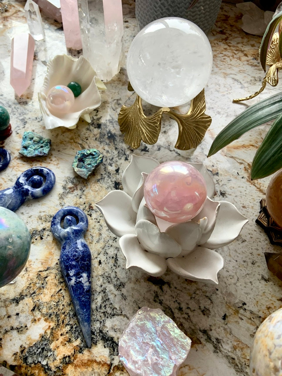 A crystal collection displayed with beautiful array of crystal stands and sphere holders with a divine feminine theme.