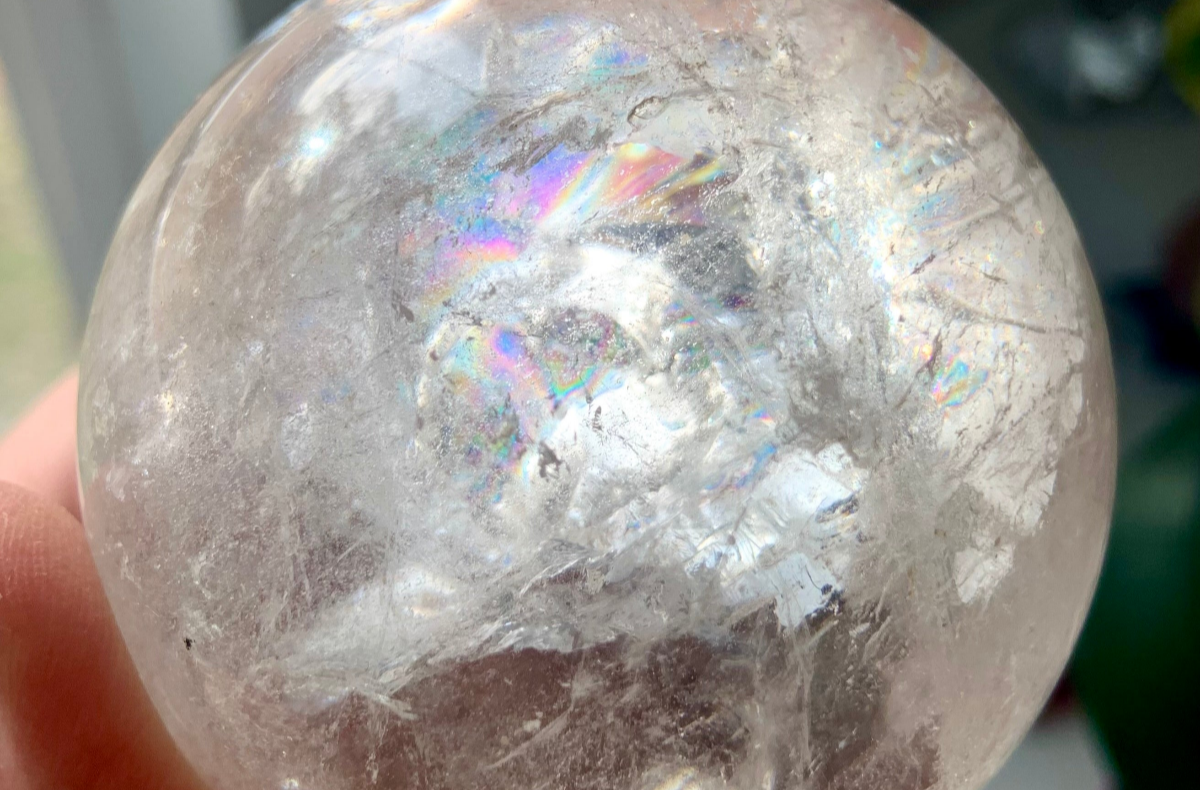 Closeup of a Clear Quartz sphere filled with rainbows — a high-vibration crystal for chakra alignment, spiritual clarity, and energetic amplification.