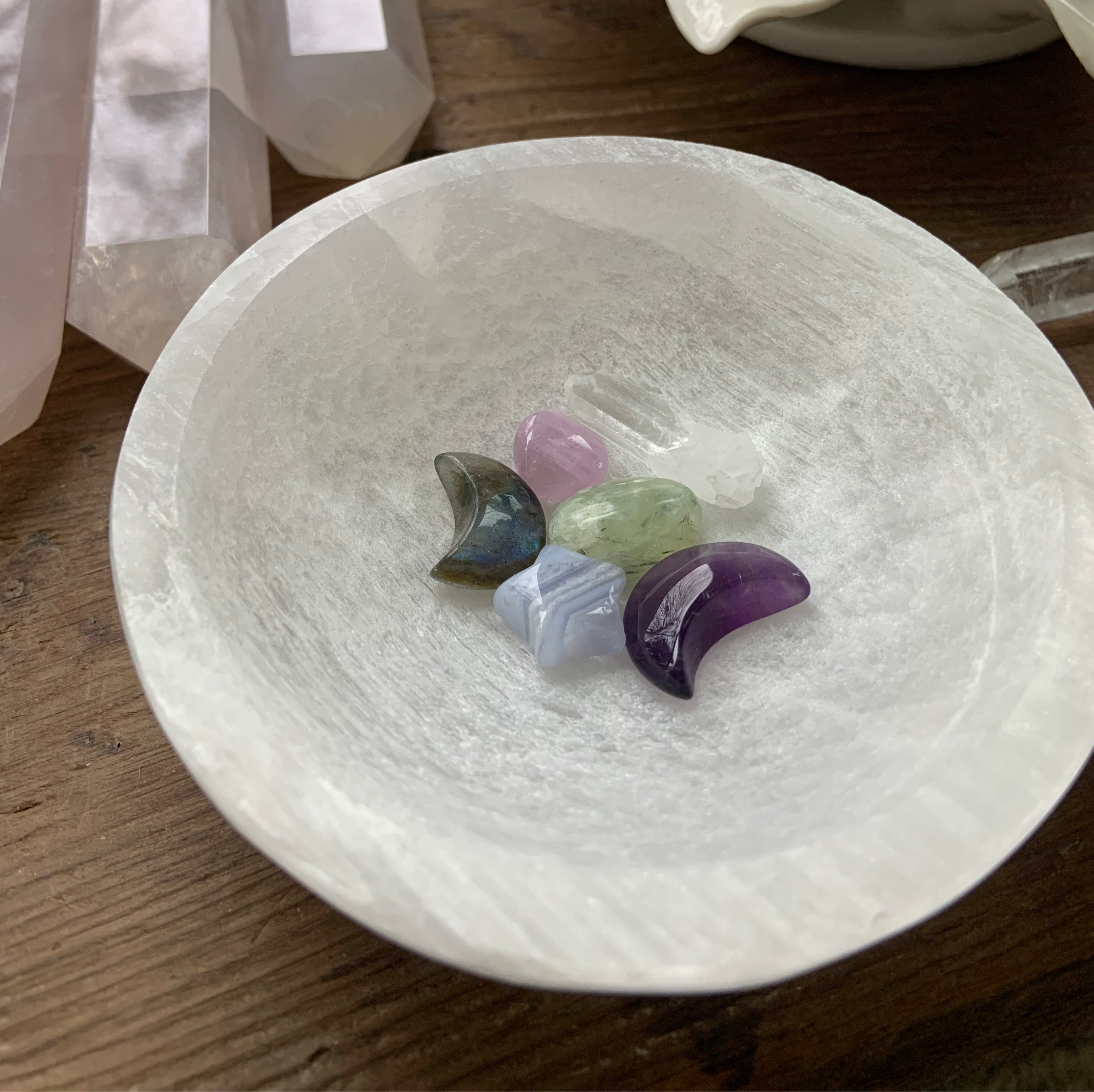 Round selenite charging bowl filled with mini crystal moons and stars — spiritual ritual tool for cleansing, charging & energy alignment.