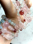 pastel gemstone bracelet held in hand with rose quartz focal bead and faceted blue topaz accents, mixed crystal bracelet for love calm and emotional healing 